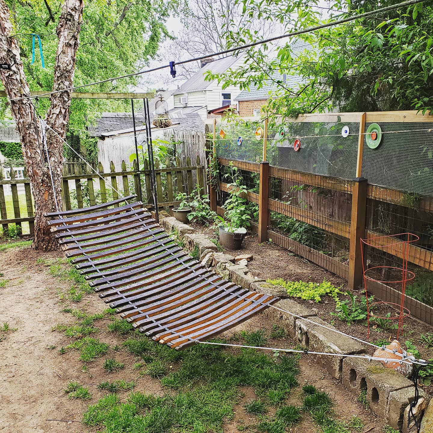 Backyard with a hammock, garden, and play structure.