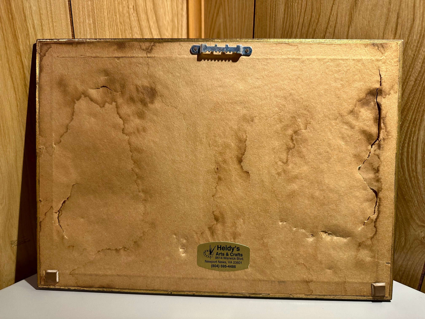 Back dustcover of Benitez painting with a 'Heidy's' label on a wooden background