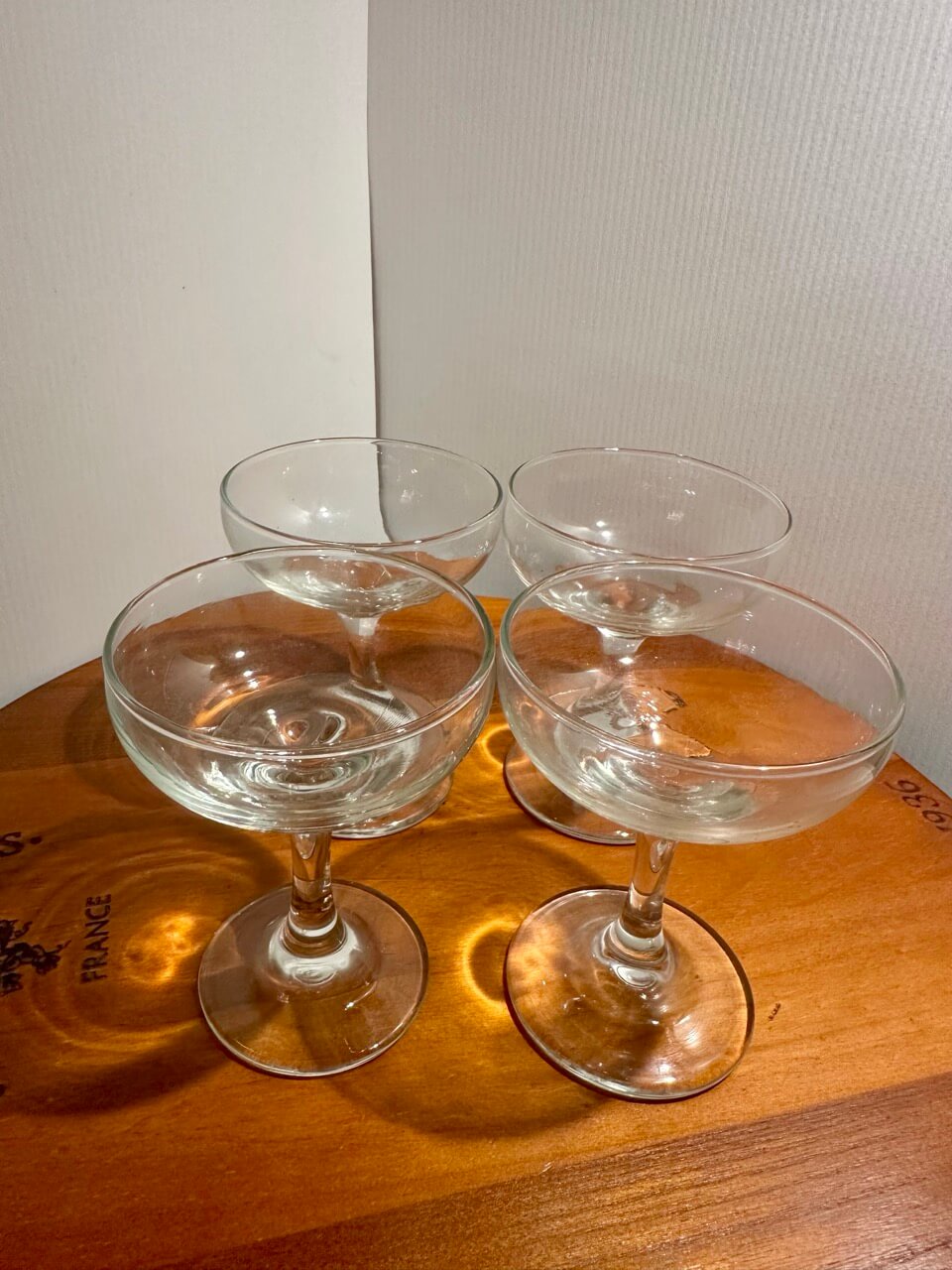 Four cocktail glasses lined up in group on wooden table.