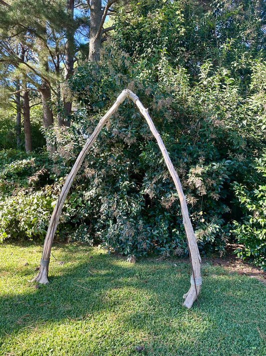 Wooden archway in a natural setting with trees and greenery