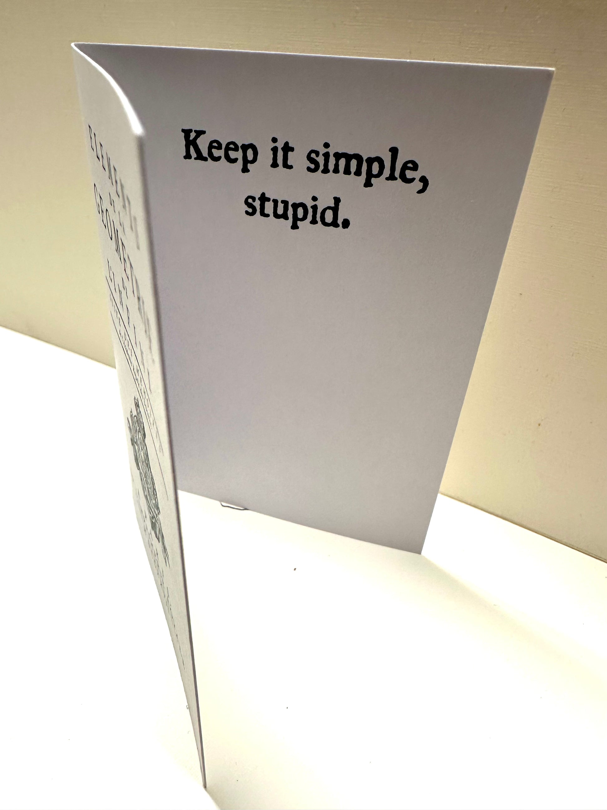 Inside fold of the 'Unnecessary Complications Card' that reads: Keep it simple, stupid.
