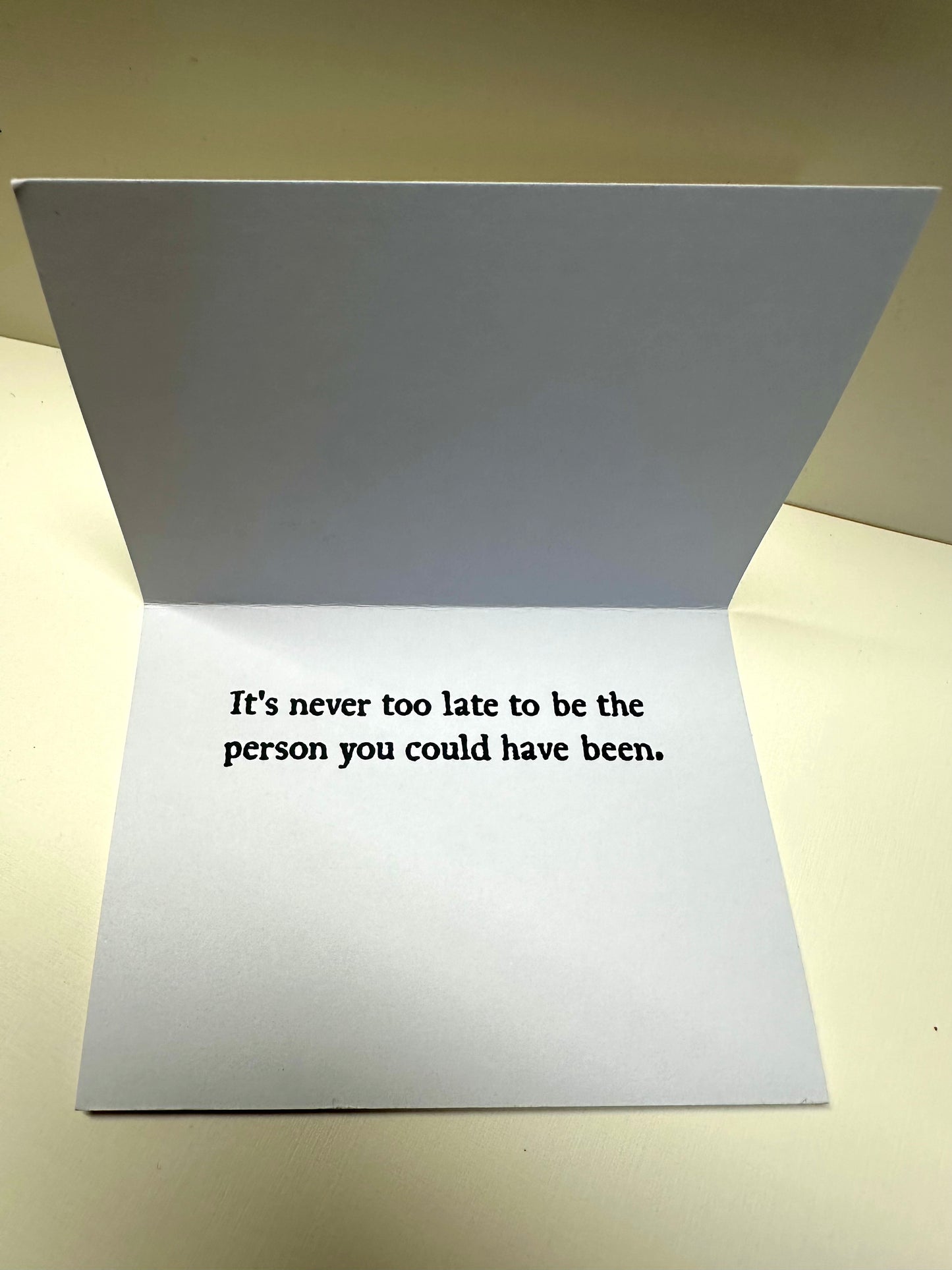 Interior flap of 'Stasis Card' that says: It's never too late to be the person you could have been.
