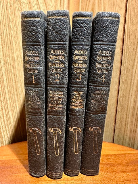 Set of four books titled 'Aubel's Carpenters and Builders Guide' on a wooden surface.