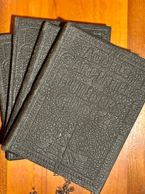 Stack of textured black books on a wooden surface