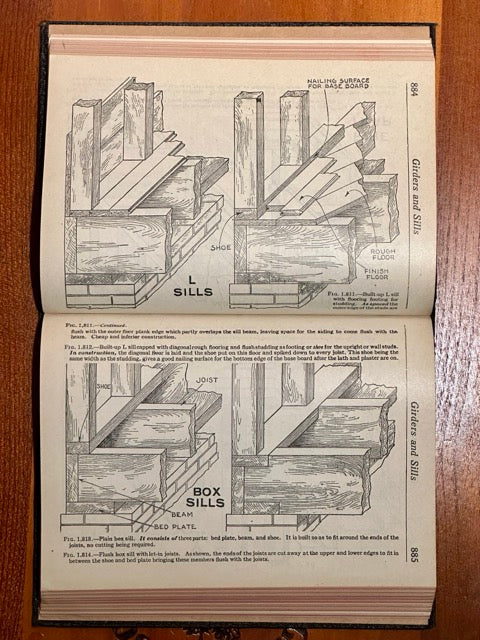 Open book with illustrations of wooden structures on a wooden surface