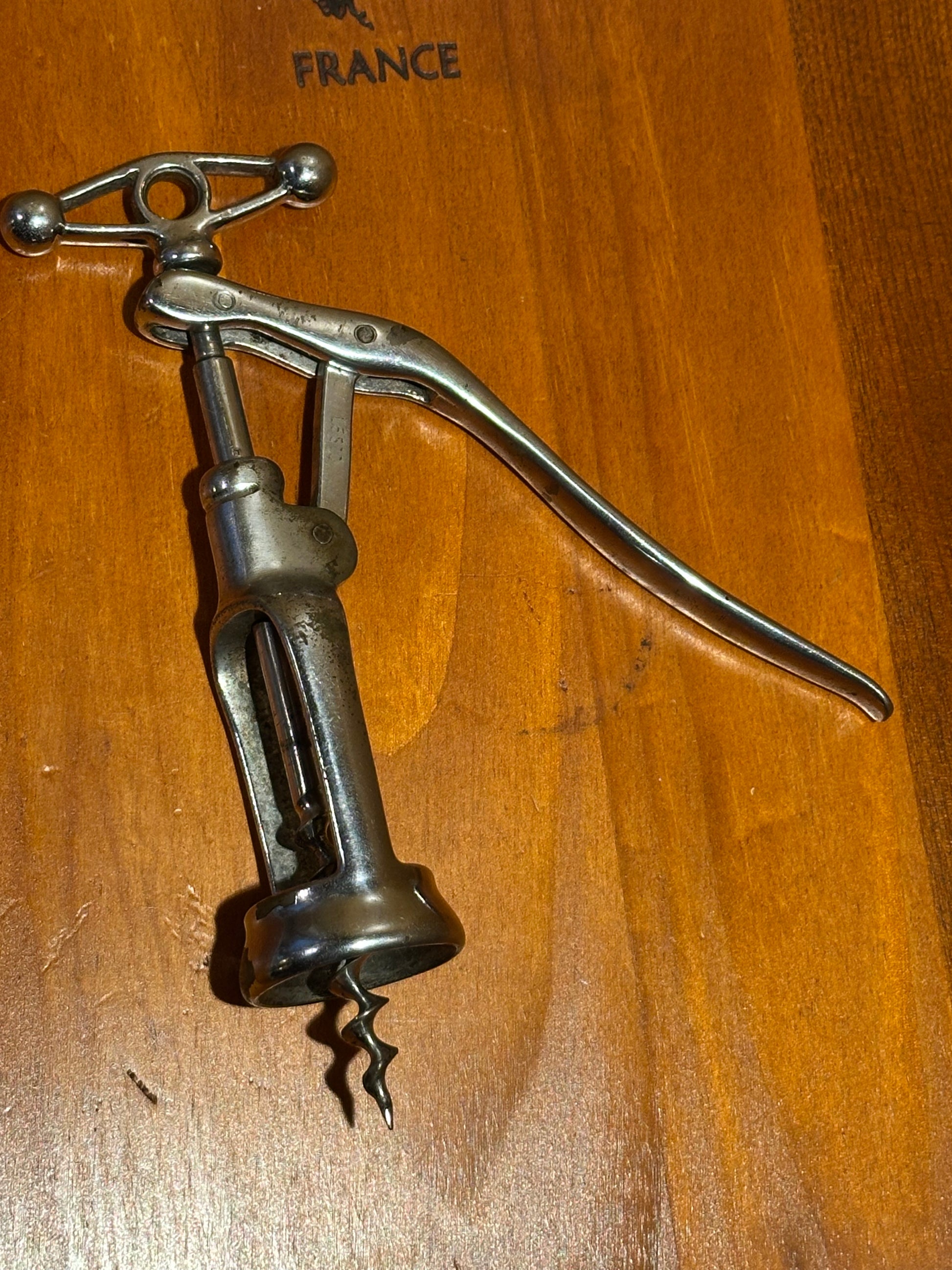 Metallic corkscrew on a wooden surface