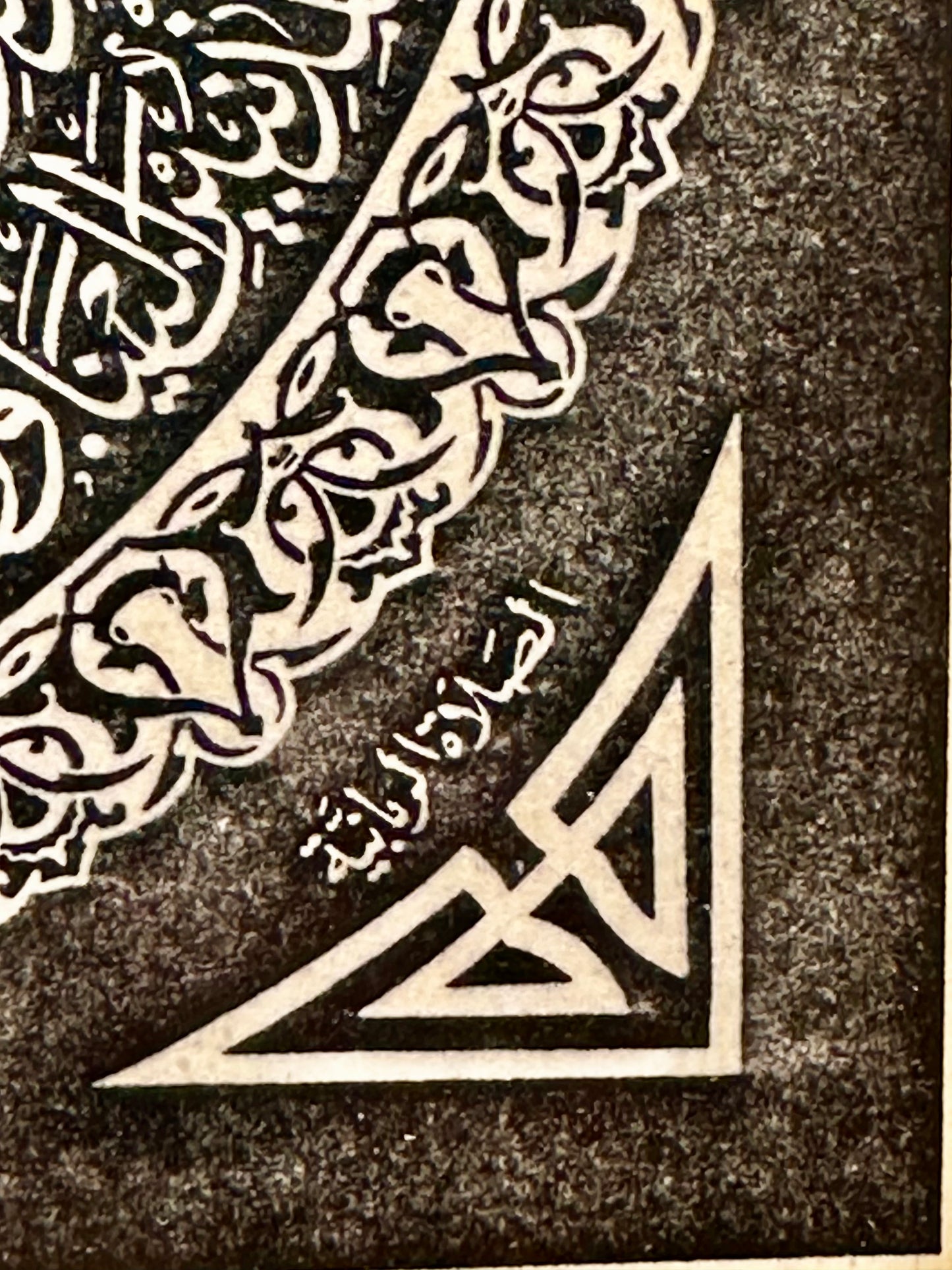 Decorative corner with Arabic calligraphy and geometric design on a textured background
