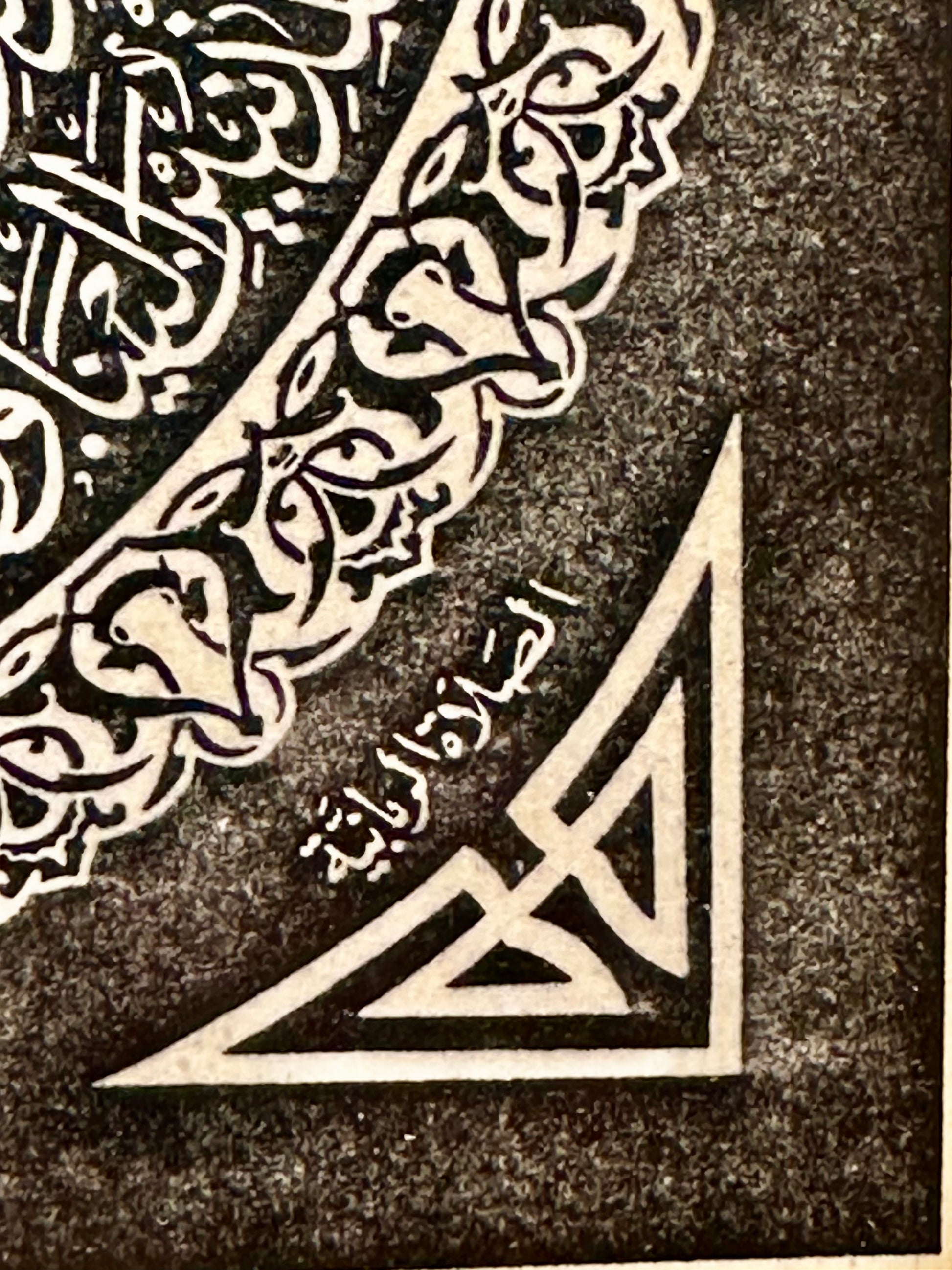 Decorative corner with Arabic calligraphy and geometric design on a textured background