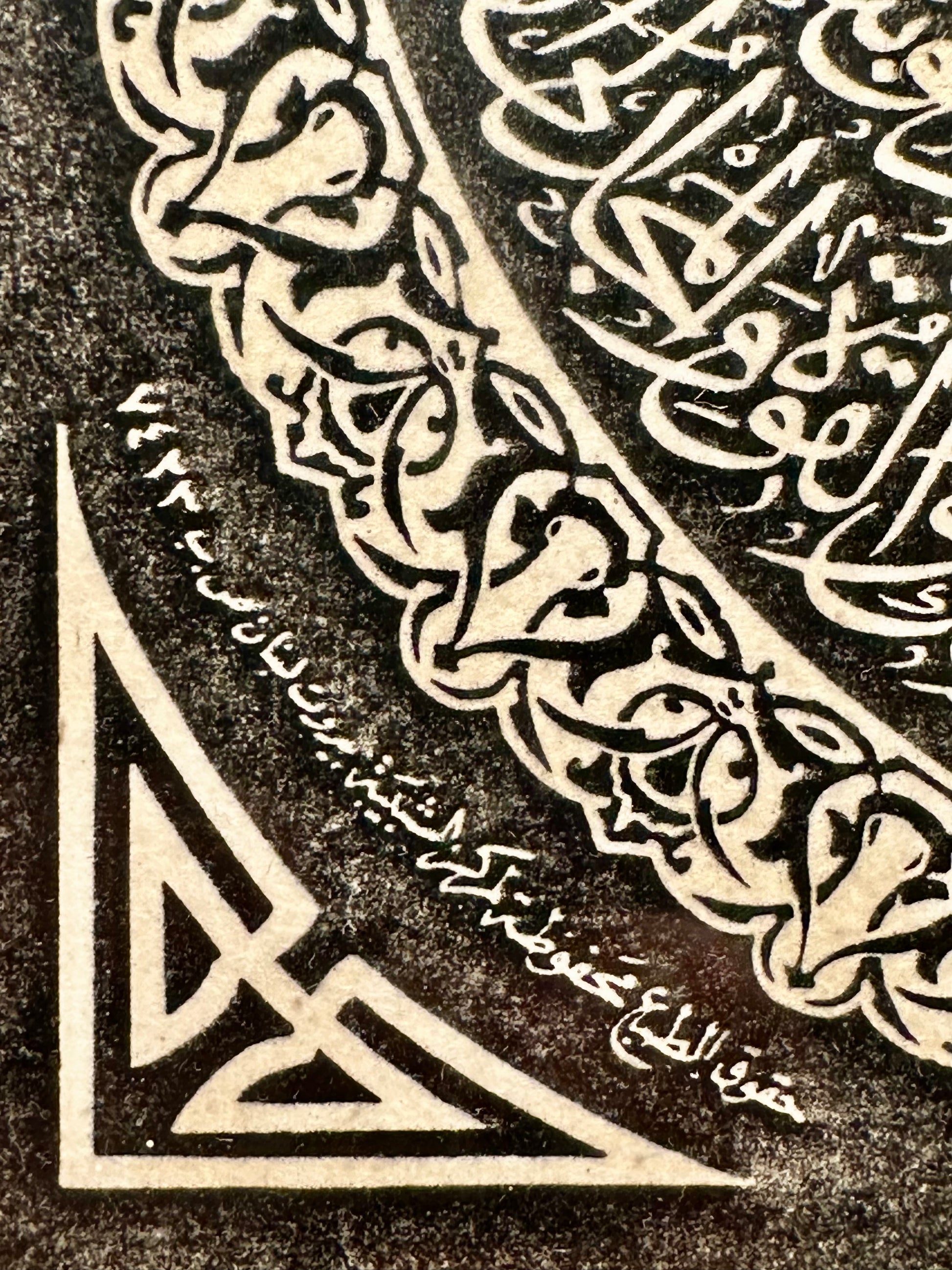 Decorative corner with Arabic calligraphy and geometric patterns on a dark background