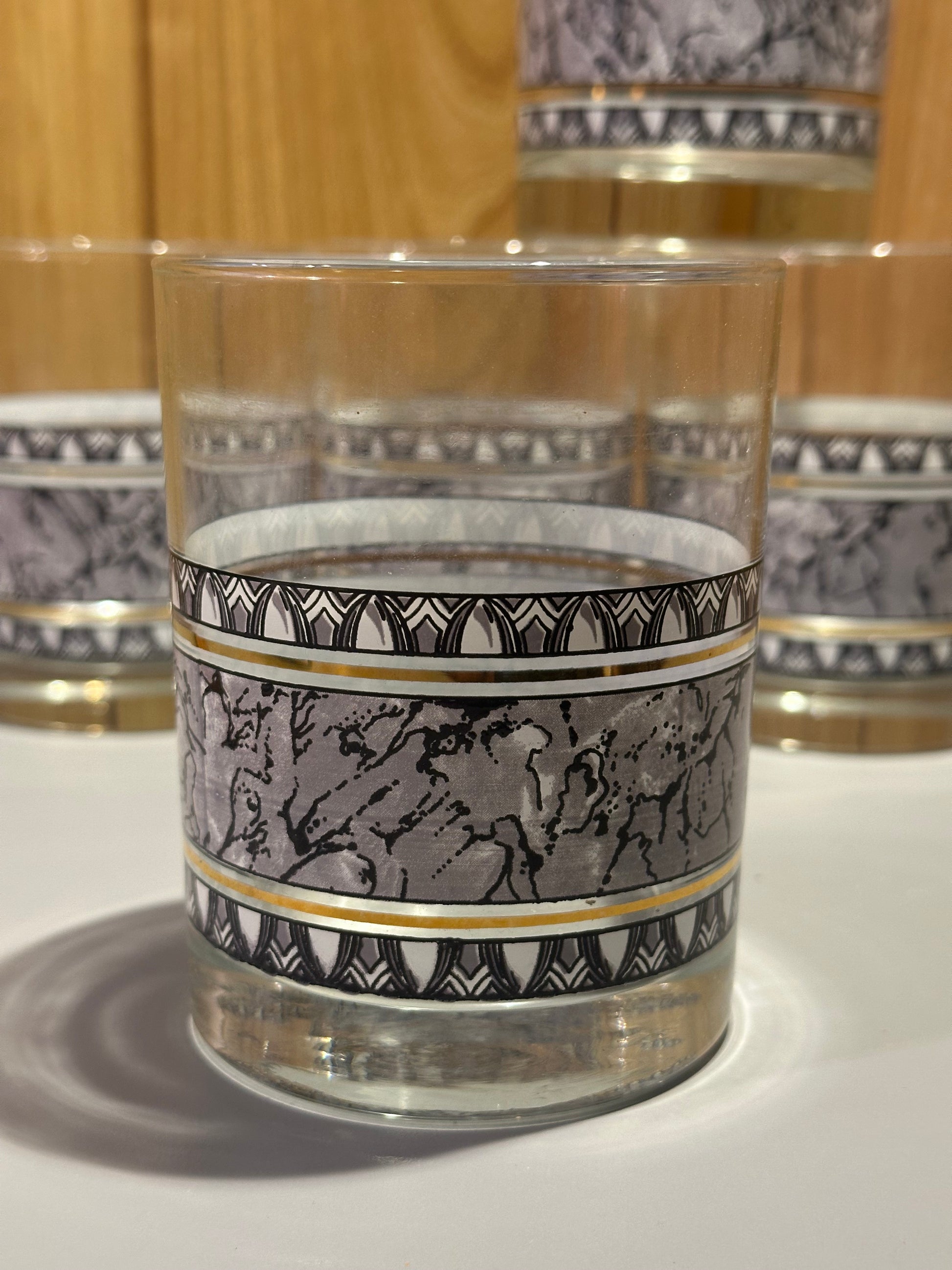 Decorative marbled motif with geometric patterns on a double rocks glass against a white background
