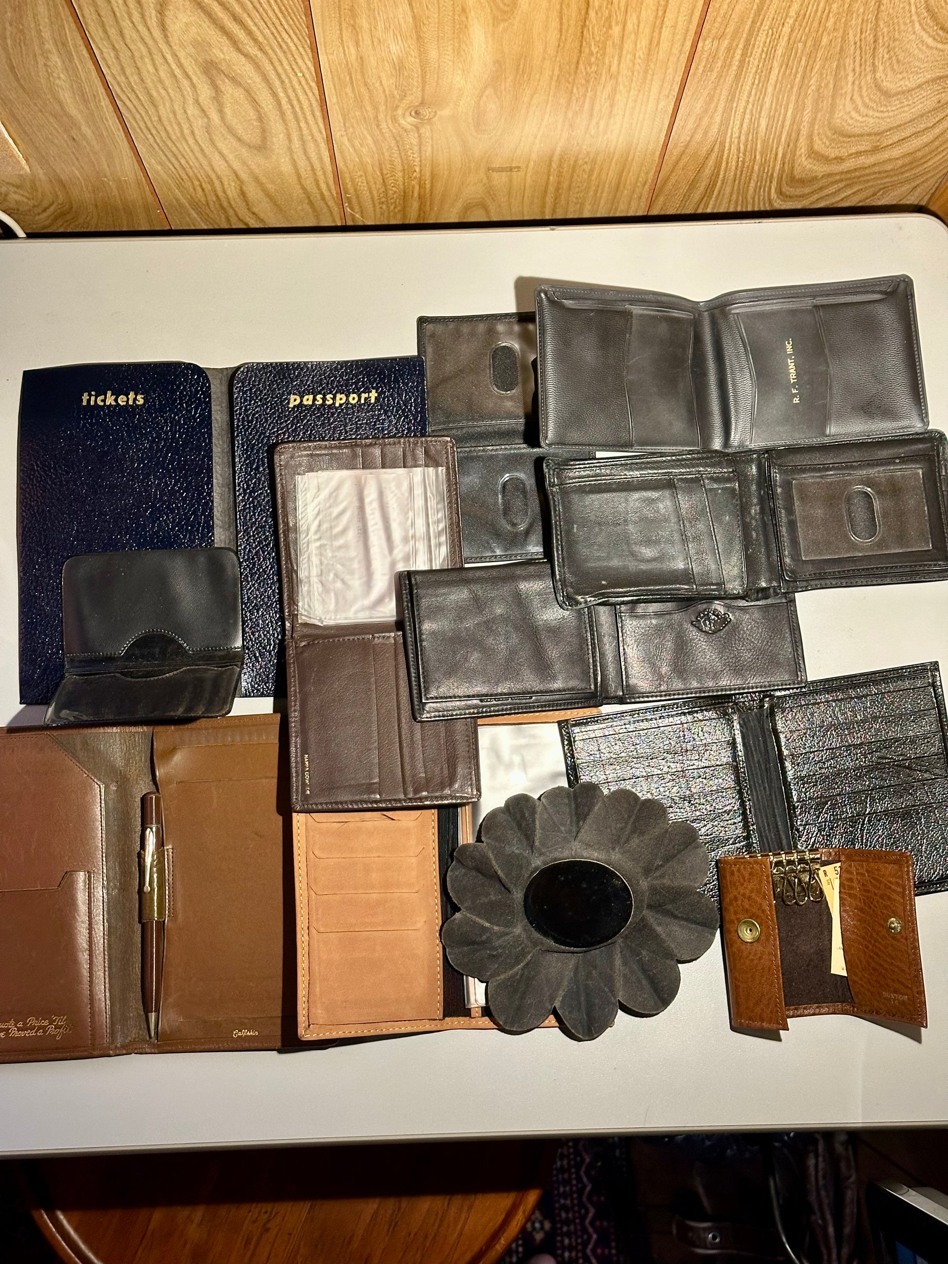 Collection of various wallets and a passport holder on a wooden surface.