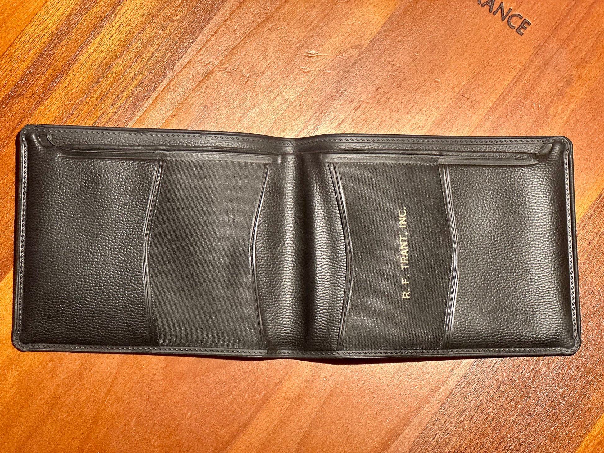 Black leather wallet on a wooden surface