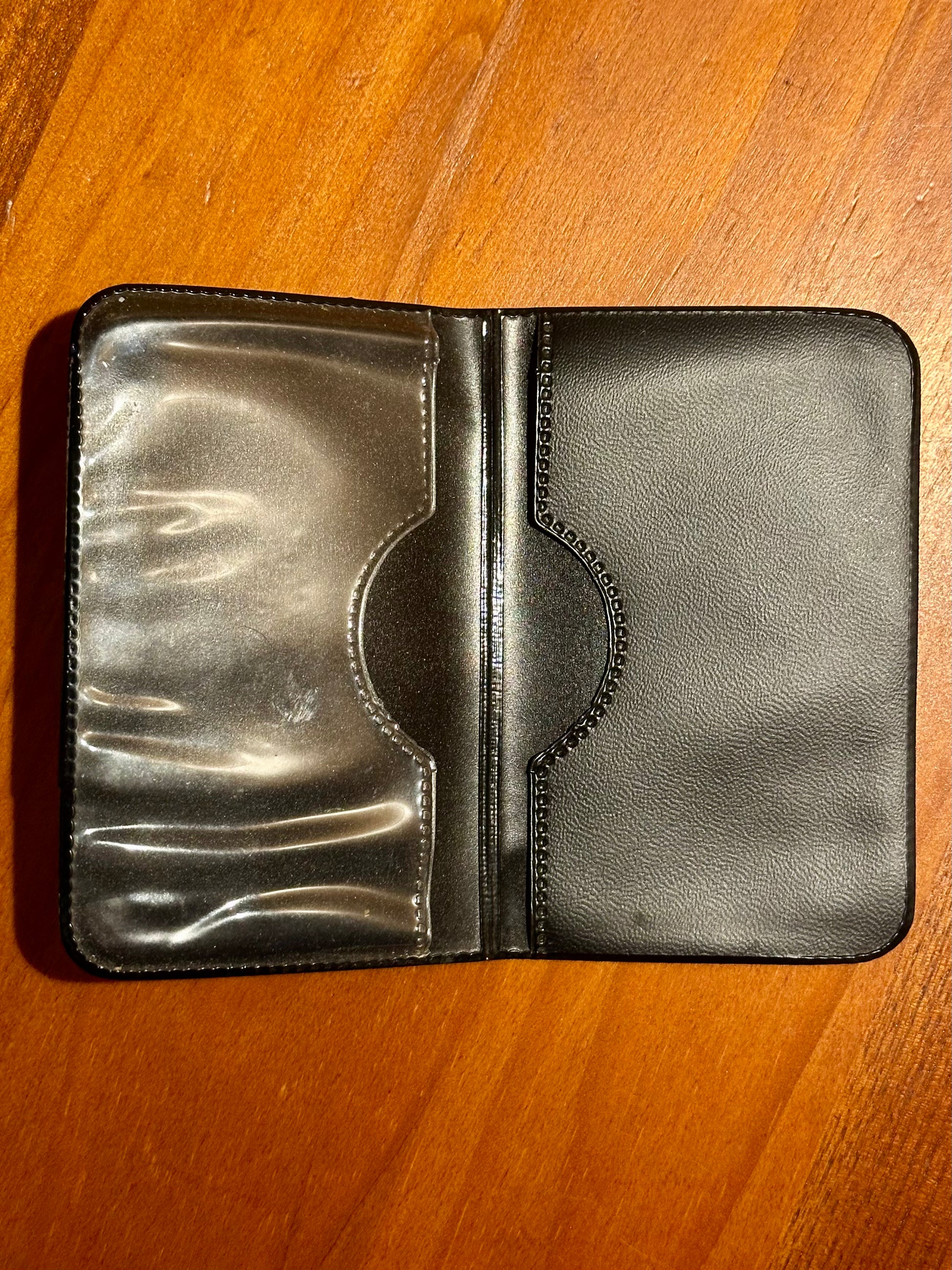 Black leather wallet on a wooden surface