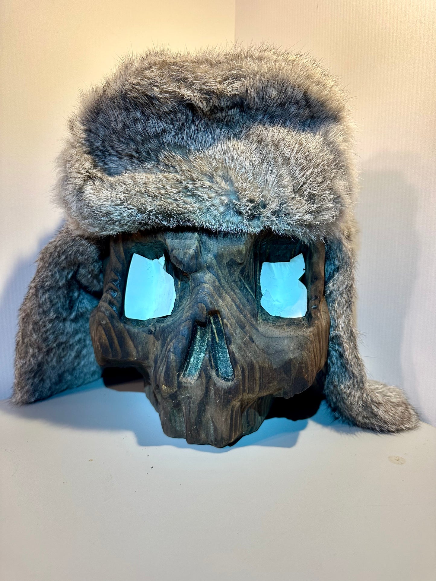 Skull-shaped object with fur-lined hat on a white background