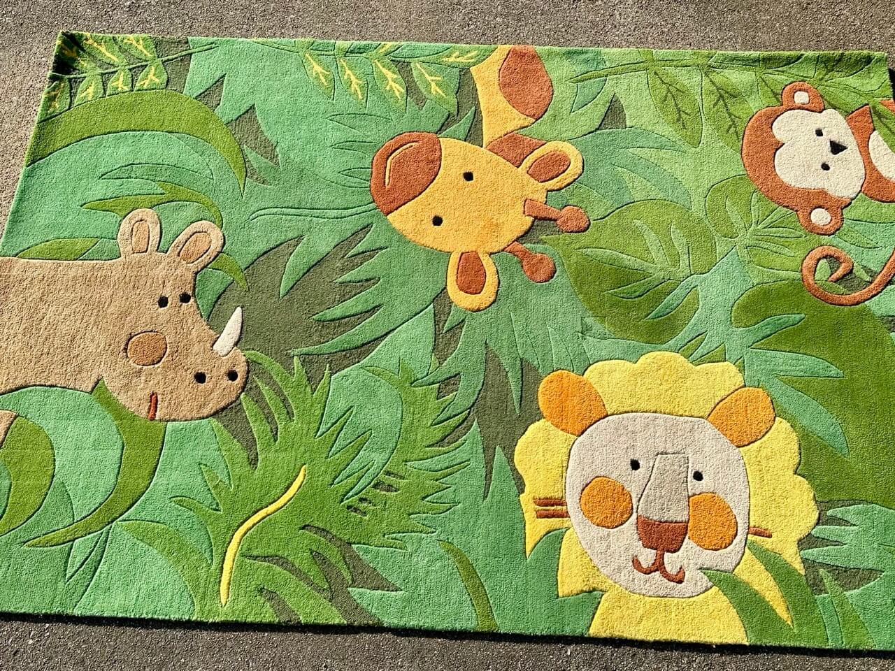 Children's rug with jungle animals design on a green background