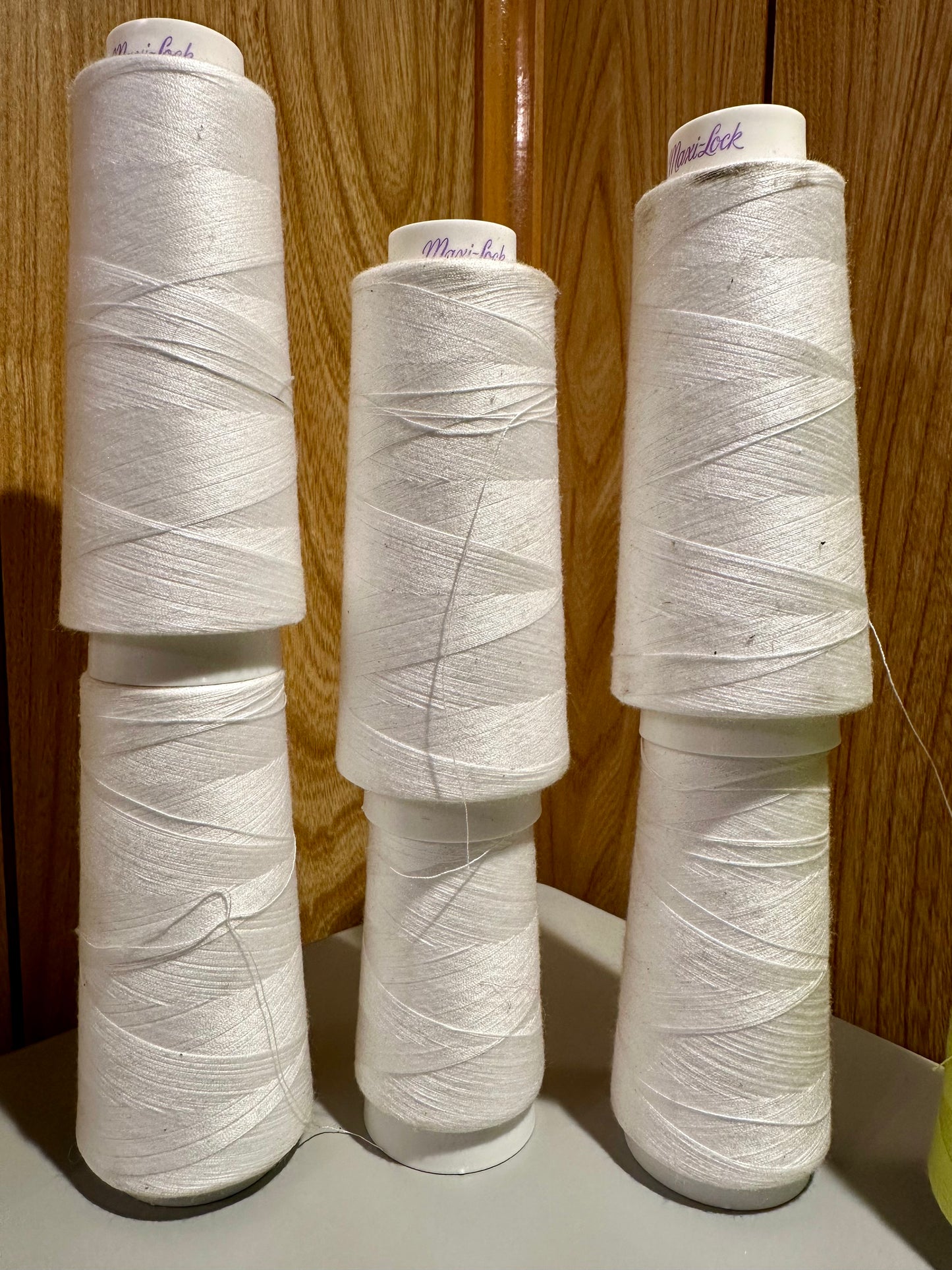 Set of white spools of thread on a wooden surface