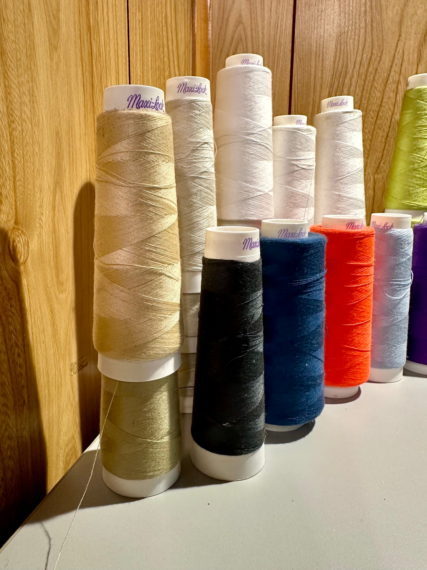 Collection of colorful thread spools on a wooden surface