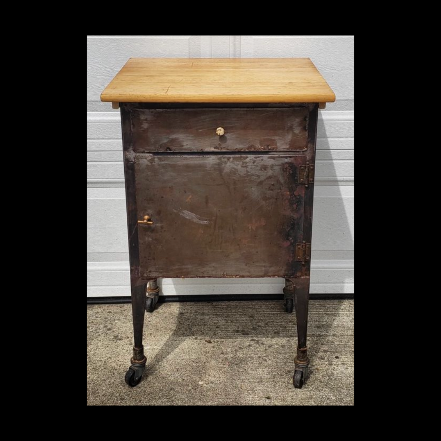 A small 1930's metal medical cabinet cleaned up with a finished wood cutting board mounted to the top.