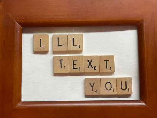 Brown wood frame with the phrase "I'll text you" spelled in scrabble letters.