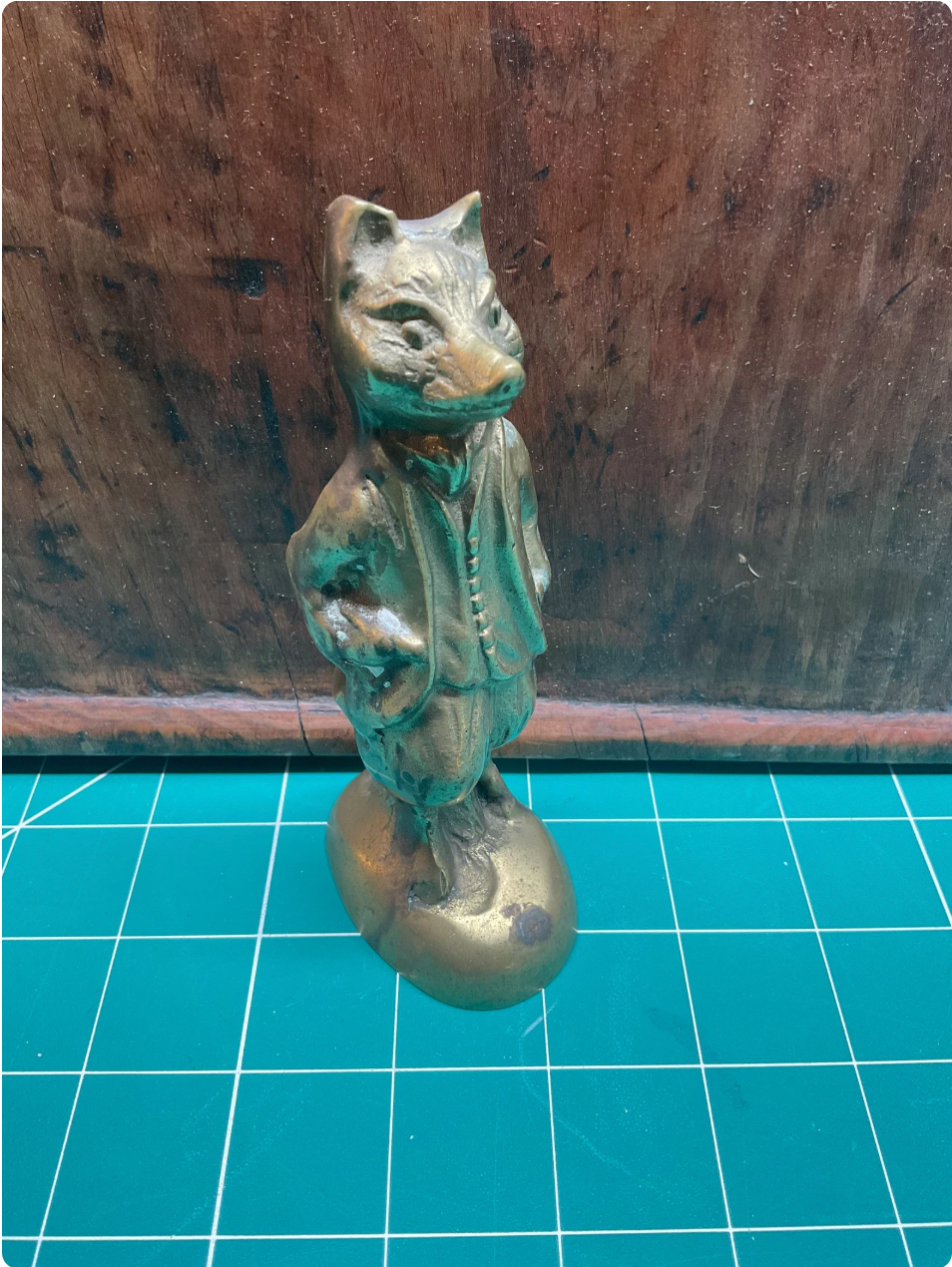 Brass fox figurine on a grid background