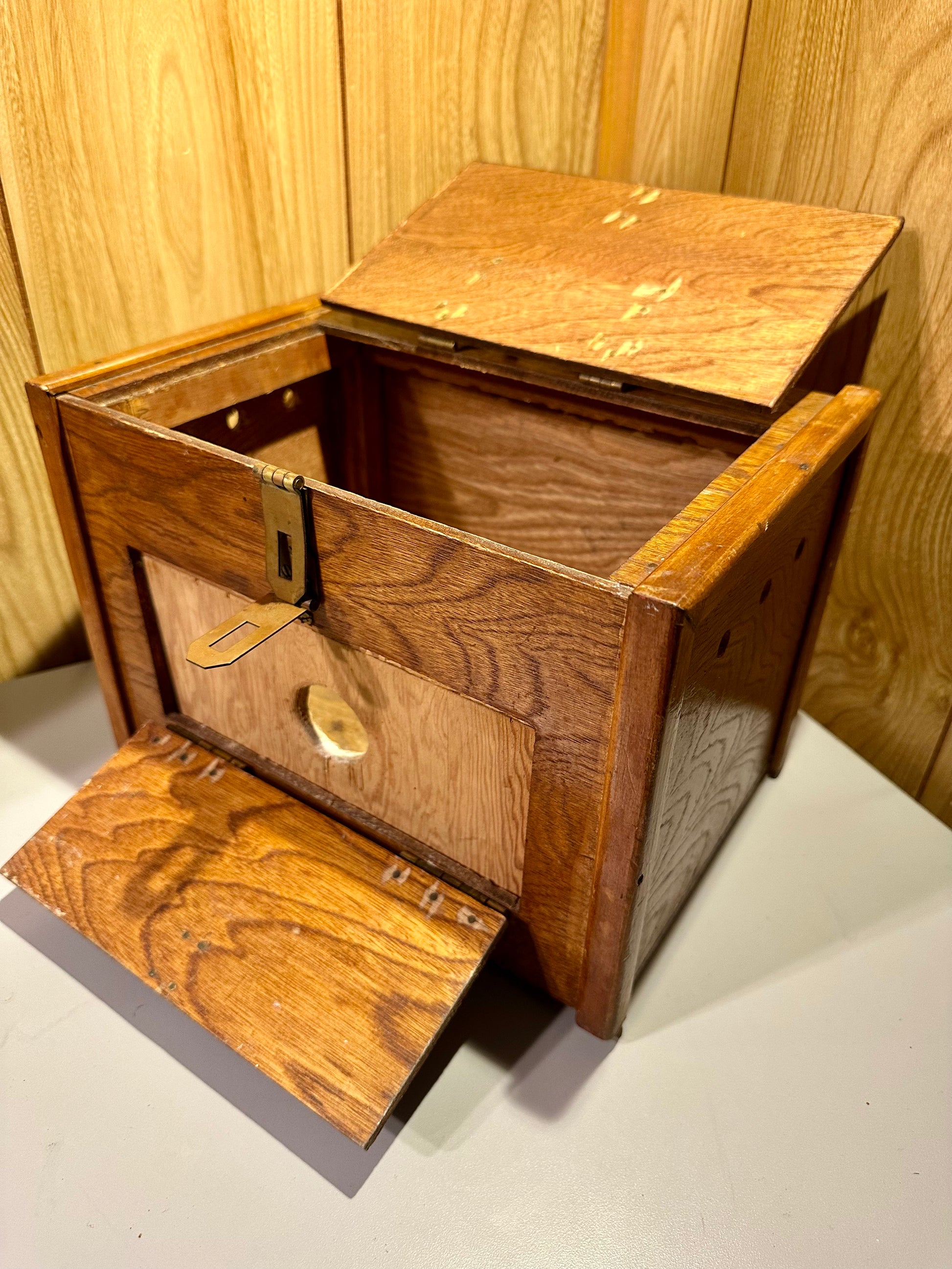 Wooden specimen box with open lid on a light wooden background