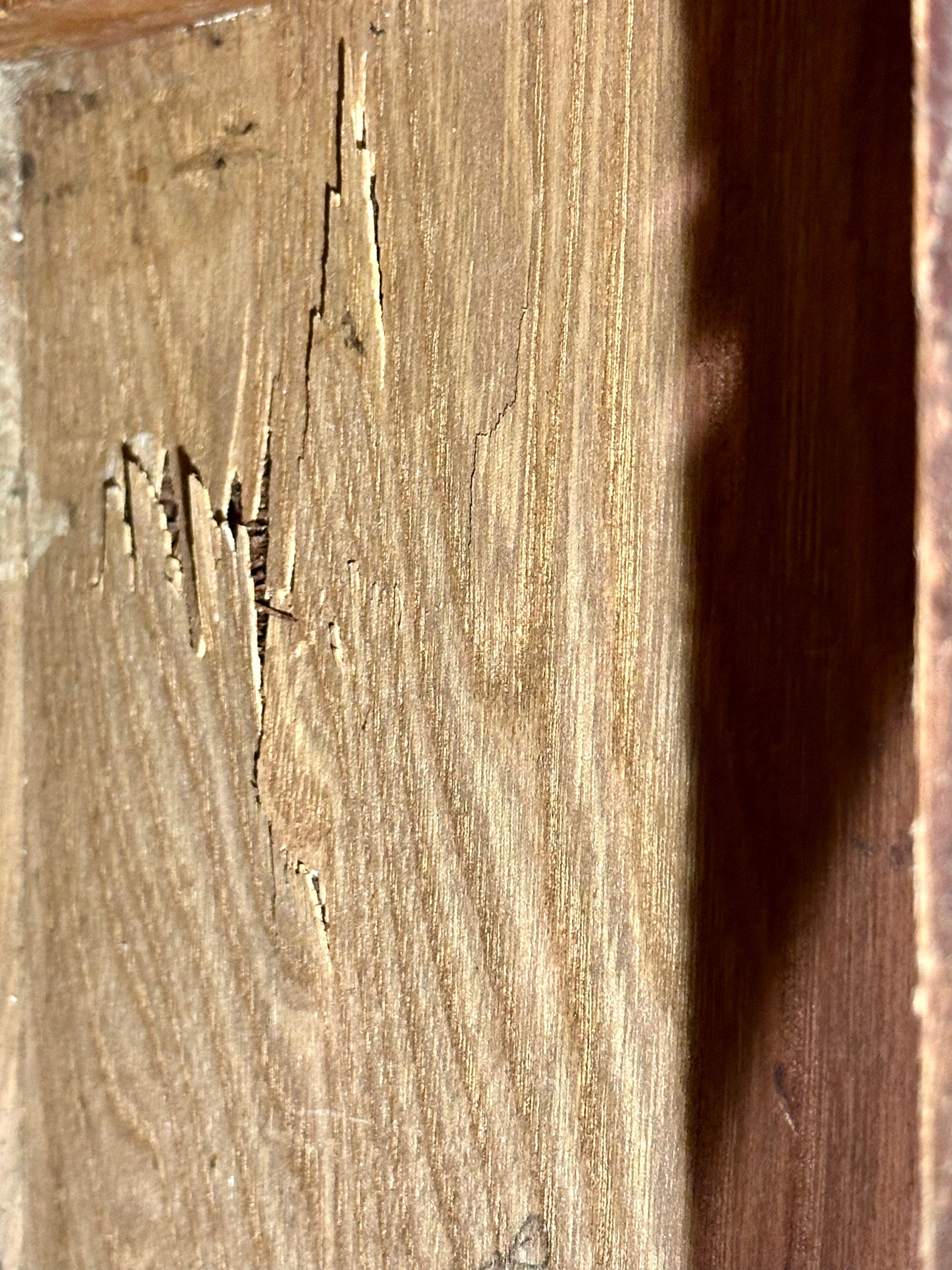 Close-up of a wooden surface with visible cracks and wear.