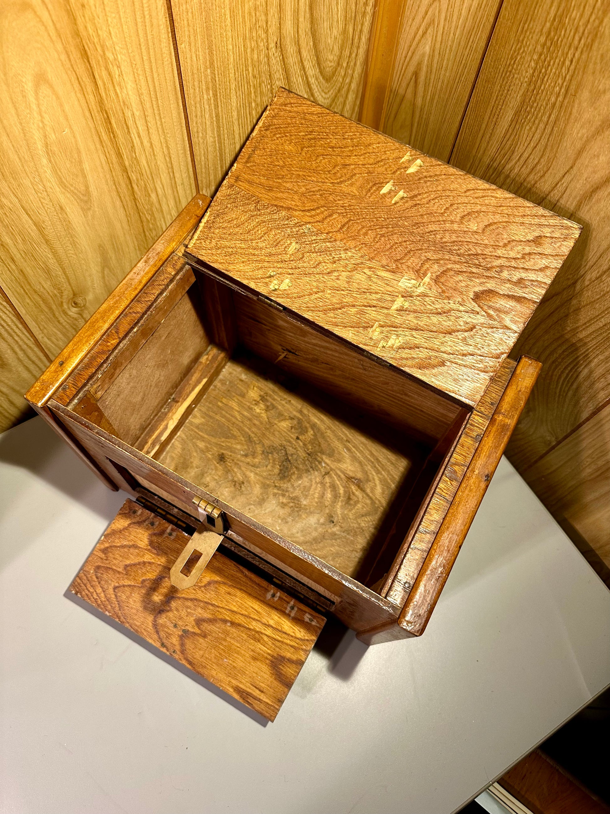 Wooden specimen box with open lid on a wooden surface