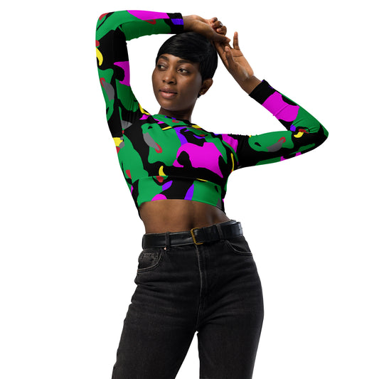 A woman posing with a long-sleeve crop top with a vibrant camouflage pattern in green, pink, and black colors.