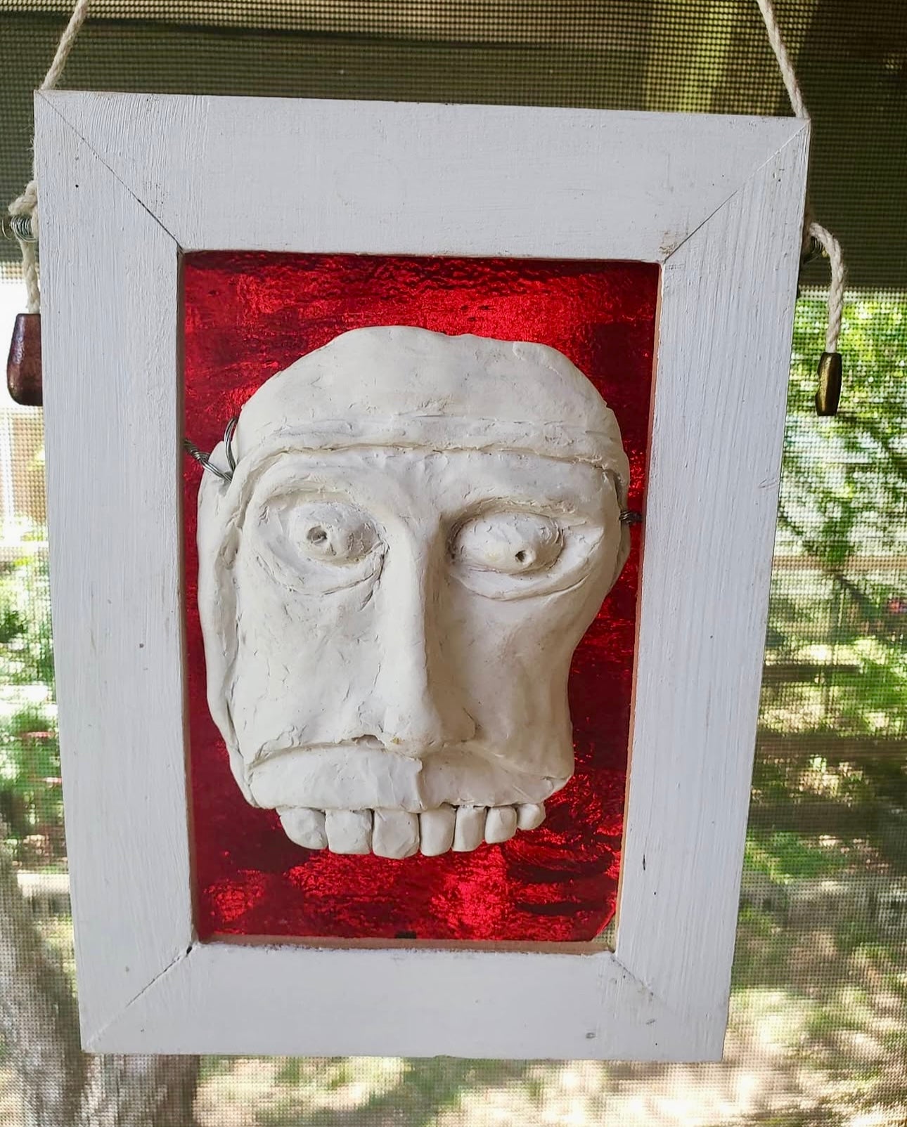 Lewis Chessman-inspired sculpture: white face on red stained glass, framed in white. Handmade in our studio.