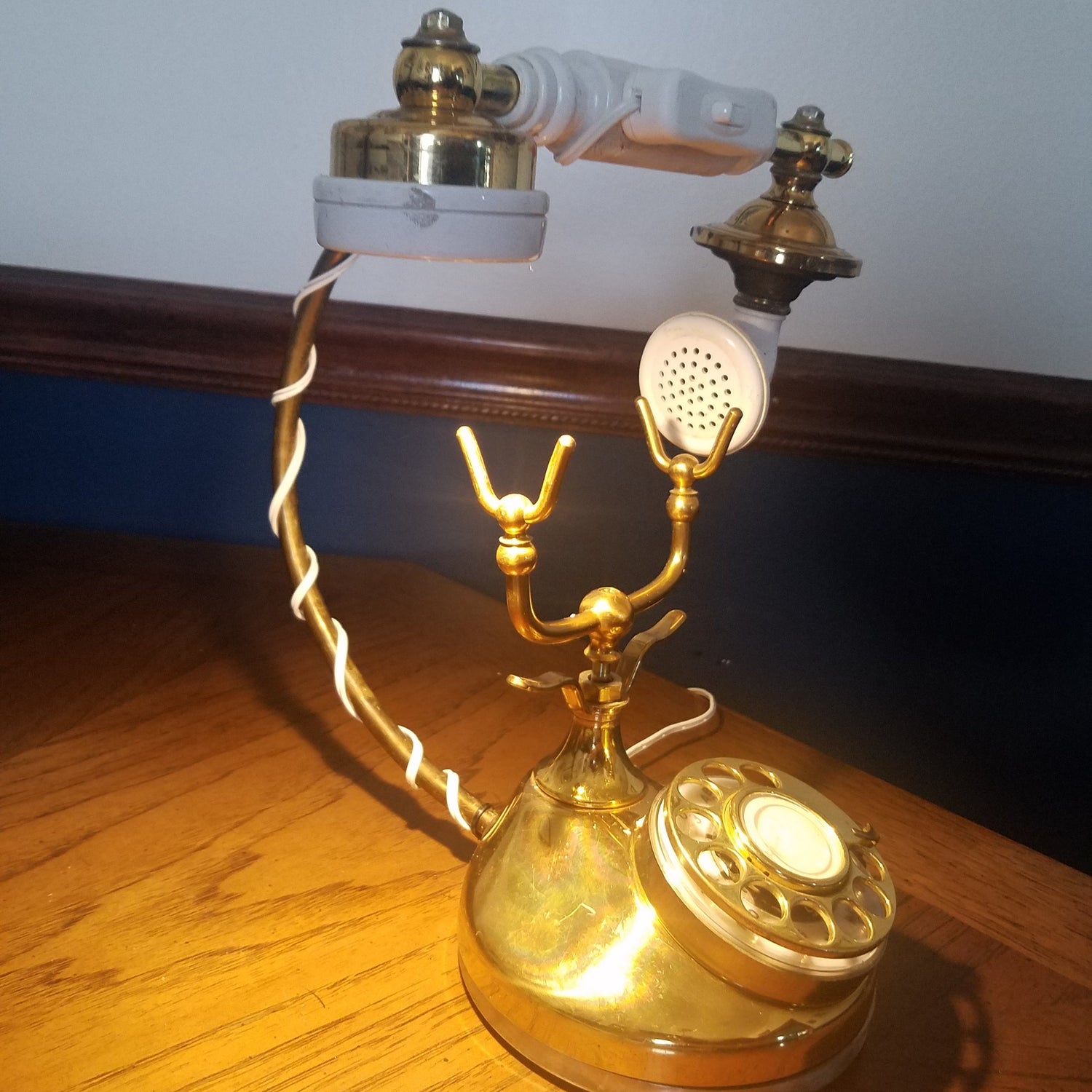 Table lamp made from a vintage brass phone with a reclaimed brass fireplace tool as handset holder. Sold in Washington, D.C.