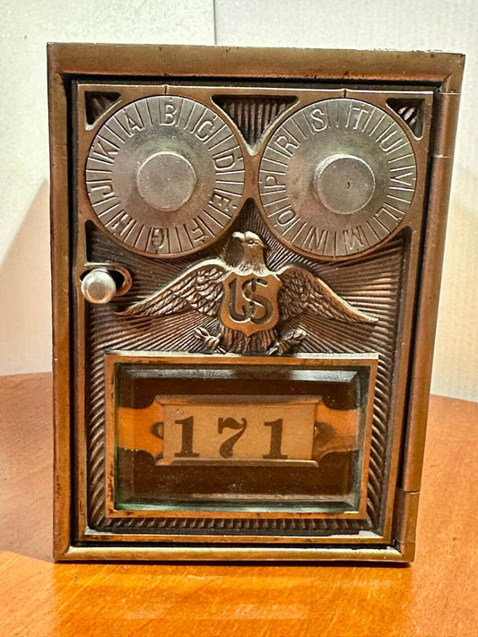 Decorative metal box with engraved design and number '171' on a wooden surface.