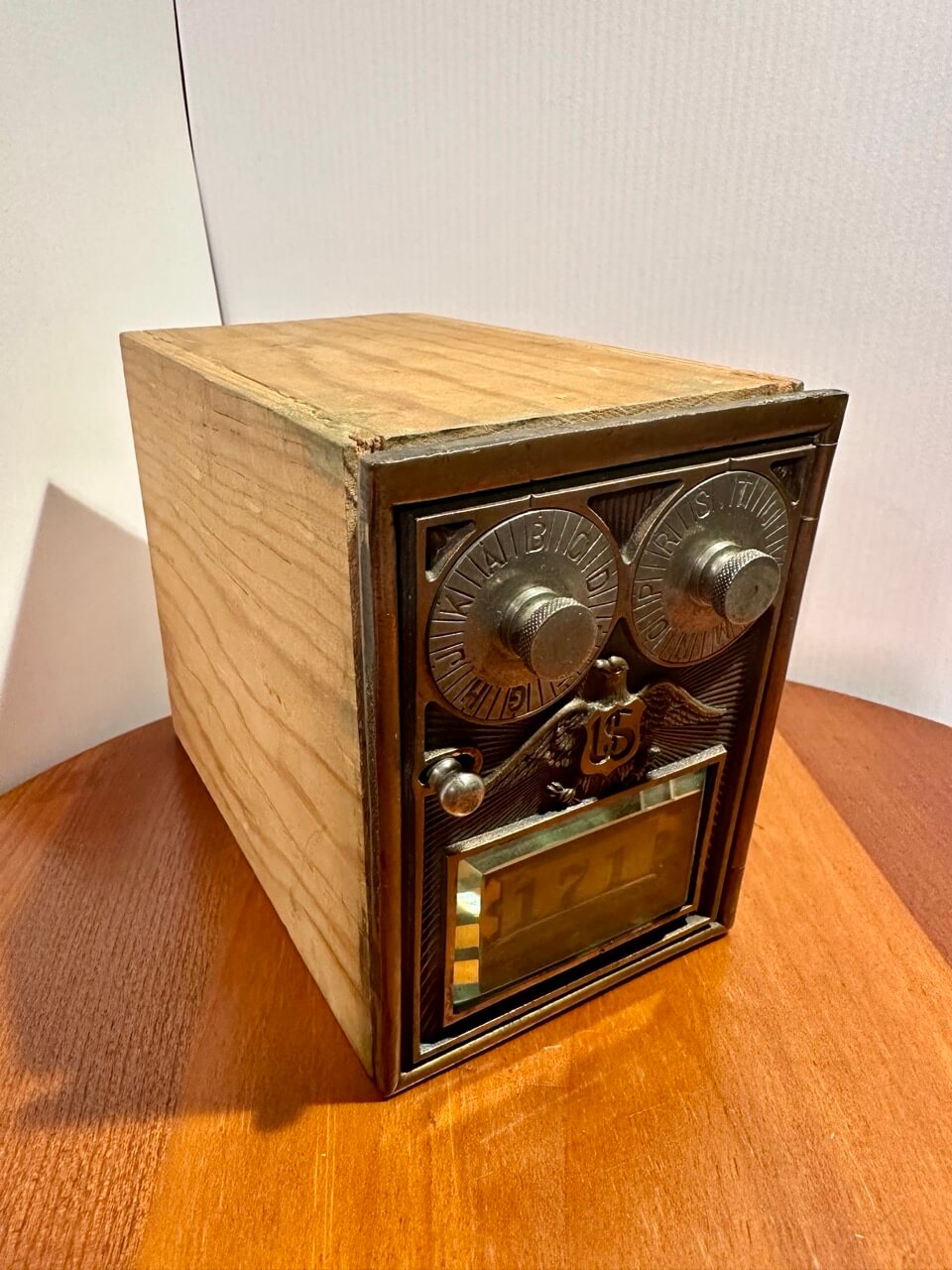 Vintage wooden bank box with metal components on a wooden surface