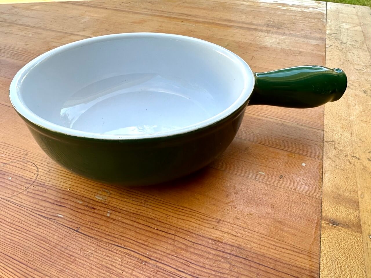 Green fondue pot on a wooden surface