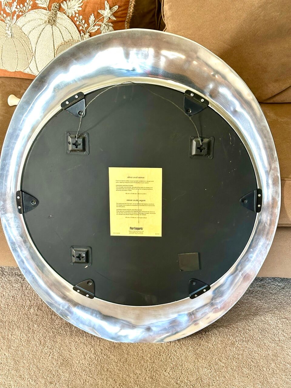 Round metallic object with a black center and yellow label on a beige surface.