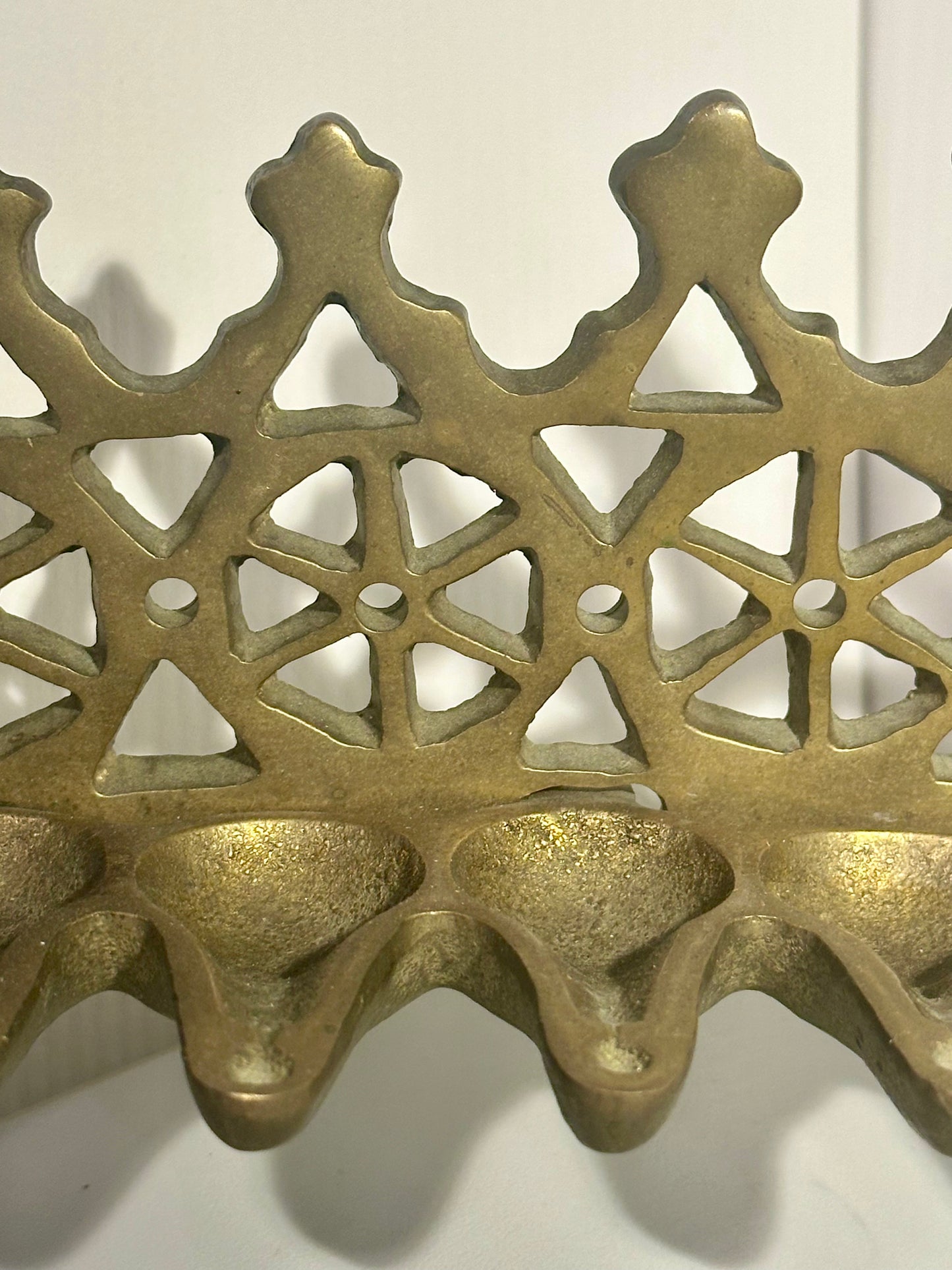 Bronze decorative item with intricate lattice design on a white background