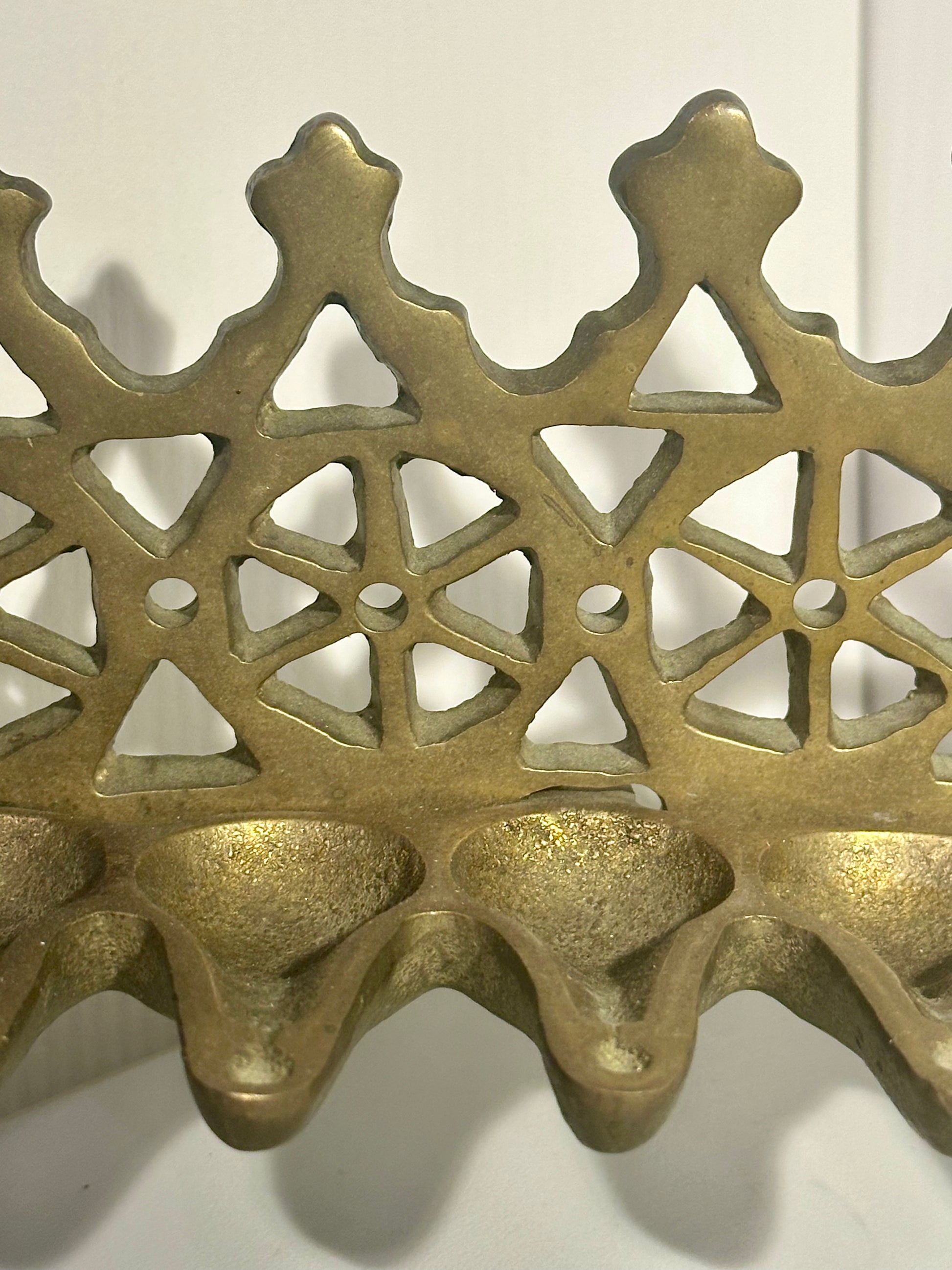 Bronze decorative item with intricate lattice design on a white background