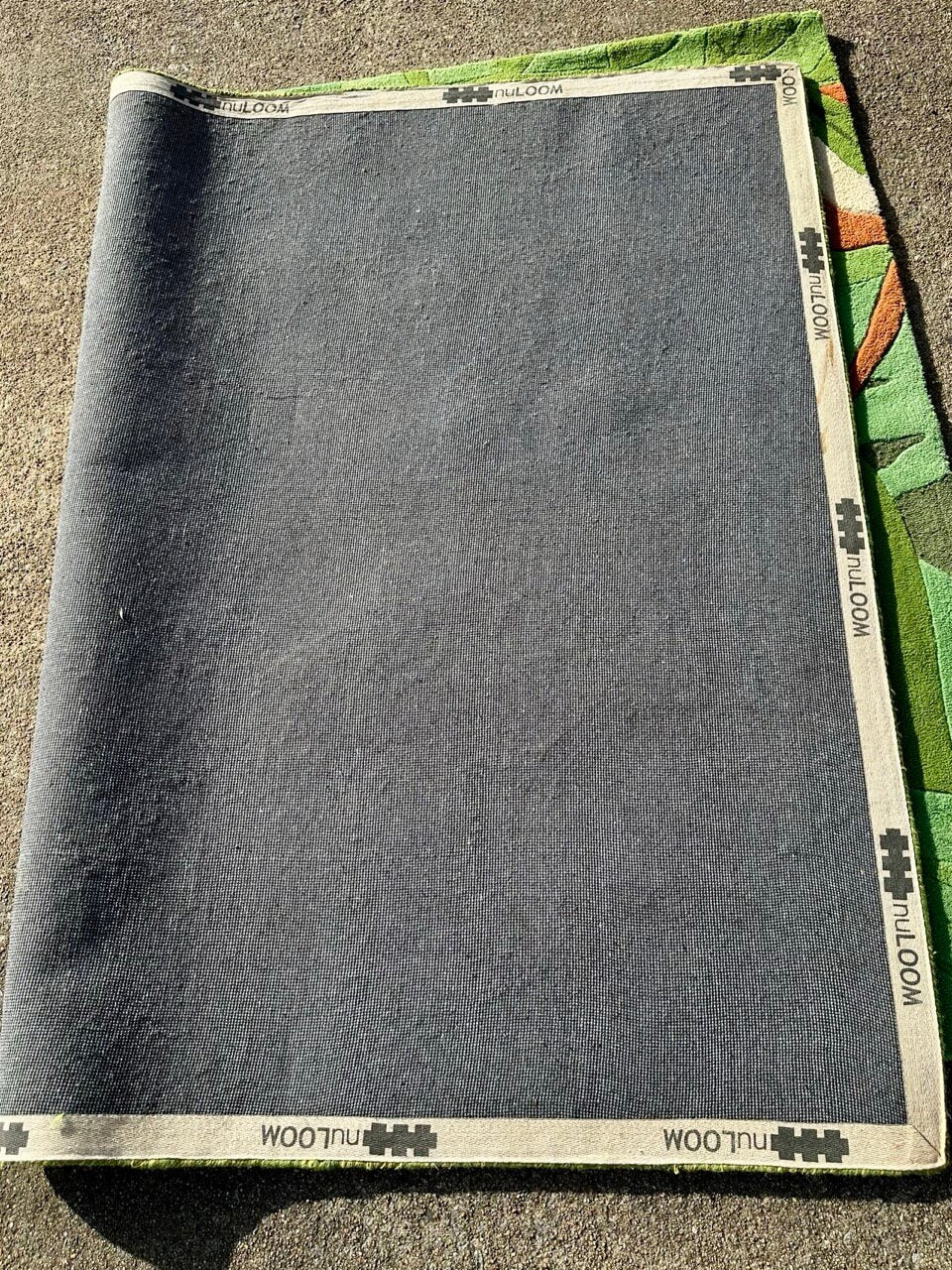 Gray backing of a folded children's rug.