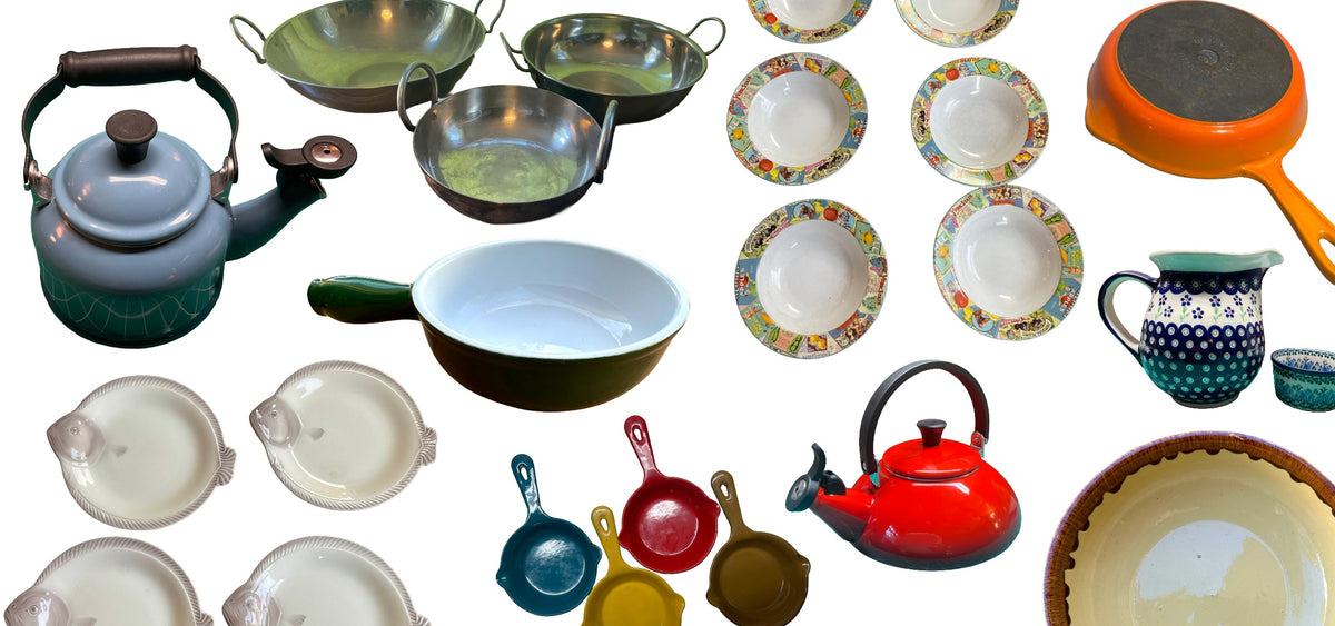 A collection of colorful kitchenware items including teapots, bowls, plates, and pans arranged on a plain white background.