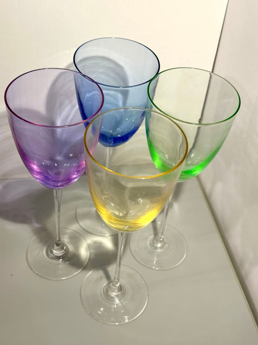 Four colorful wine glasses on a white surface