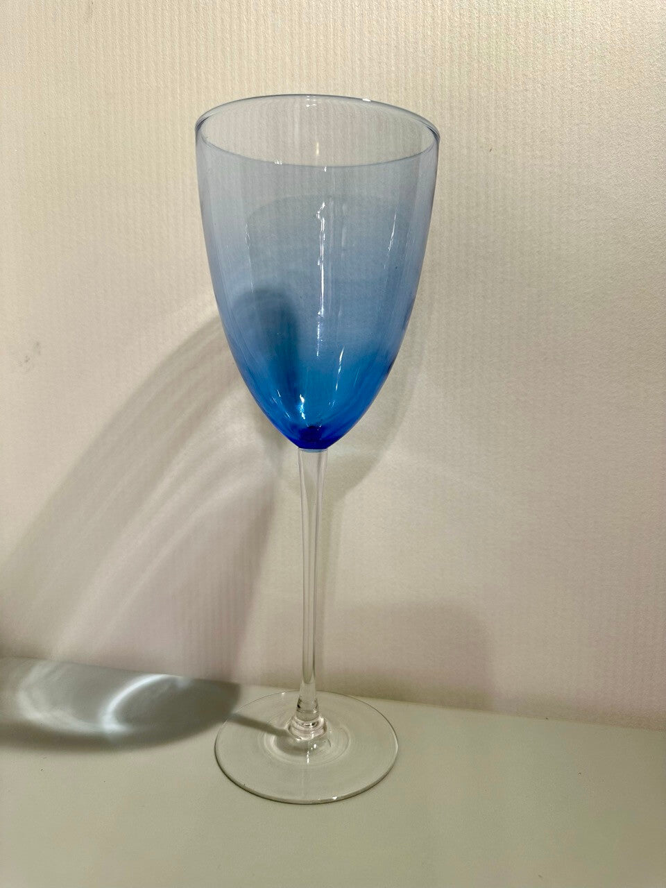 Blue-tinted wine glass on a plain background