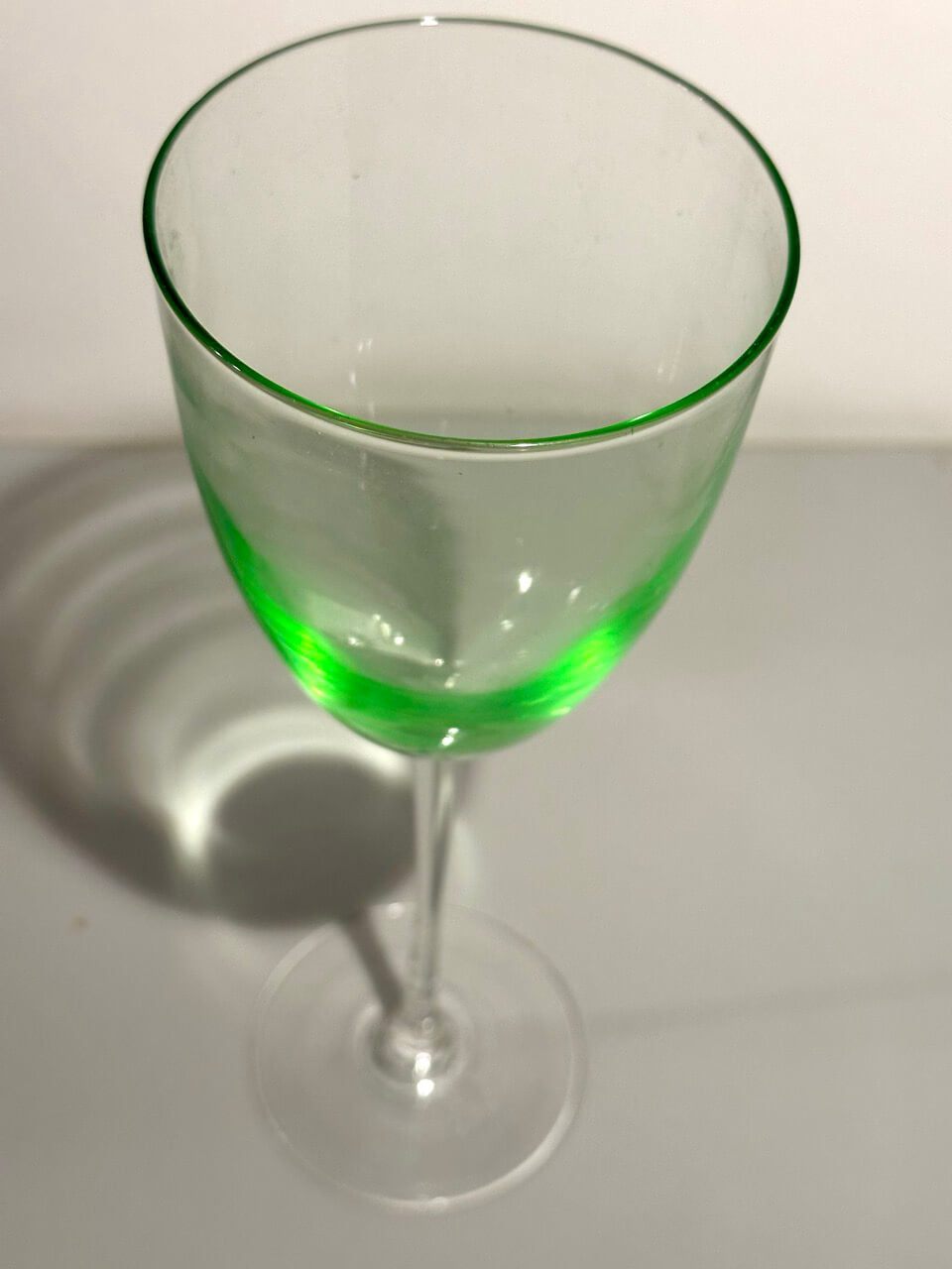 Green glass wine glass on a white background