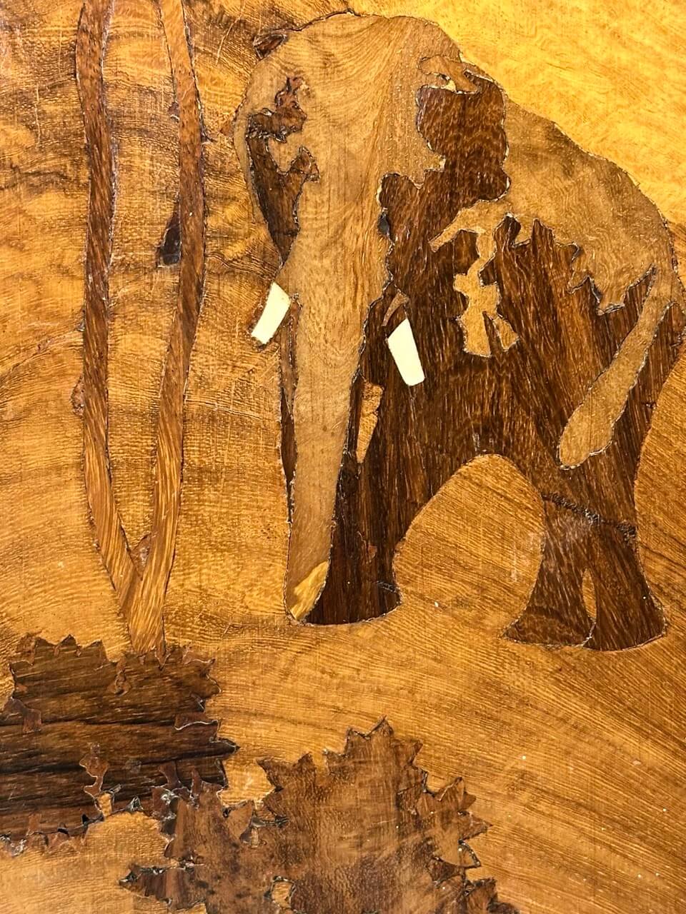Wooden inlay art of an elephant with a detailed background