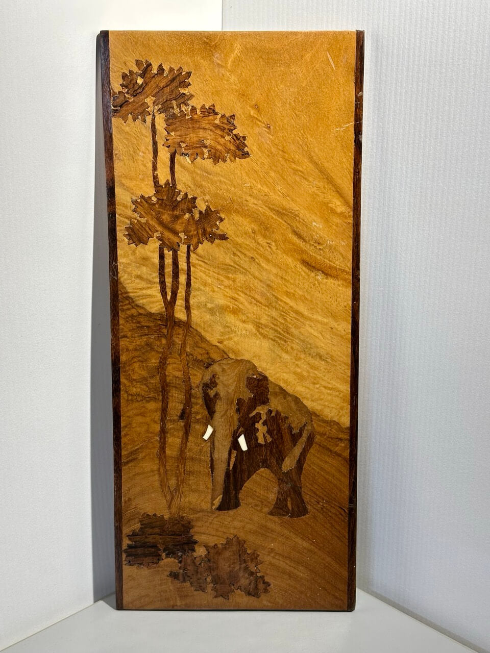 Wooden panel with elephant and tree design on a white background