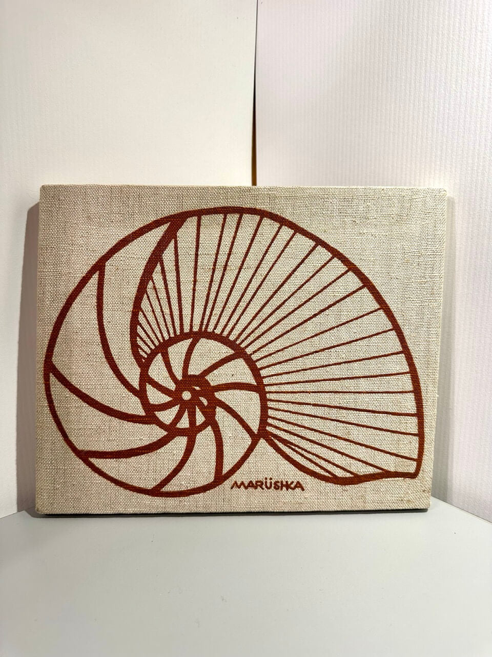 Brown silkscreen of a shell on linen.