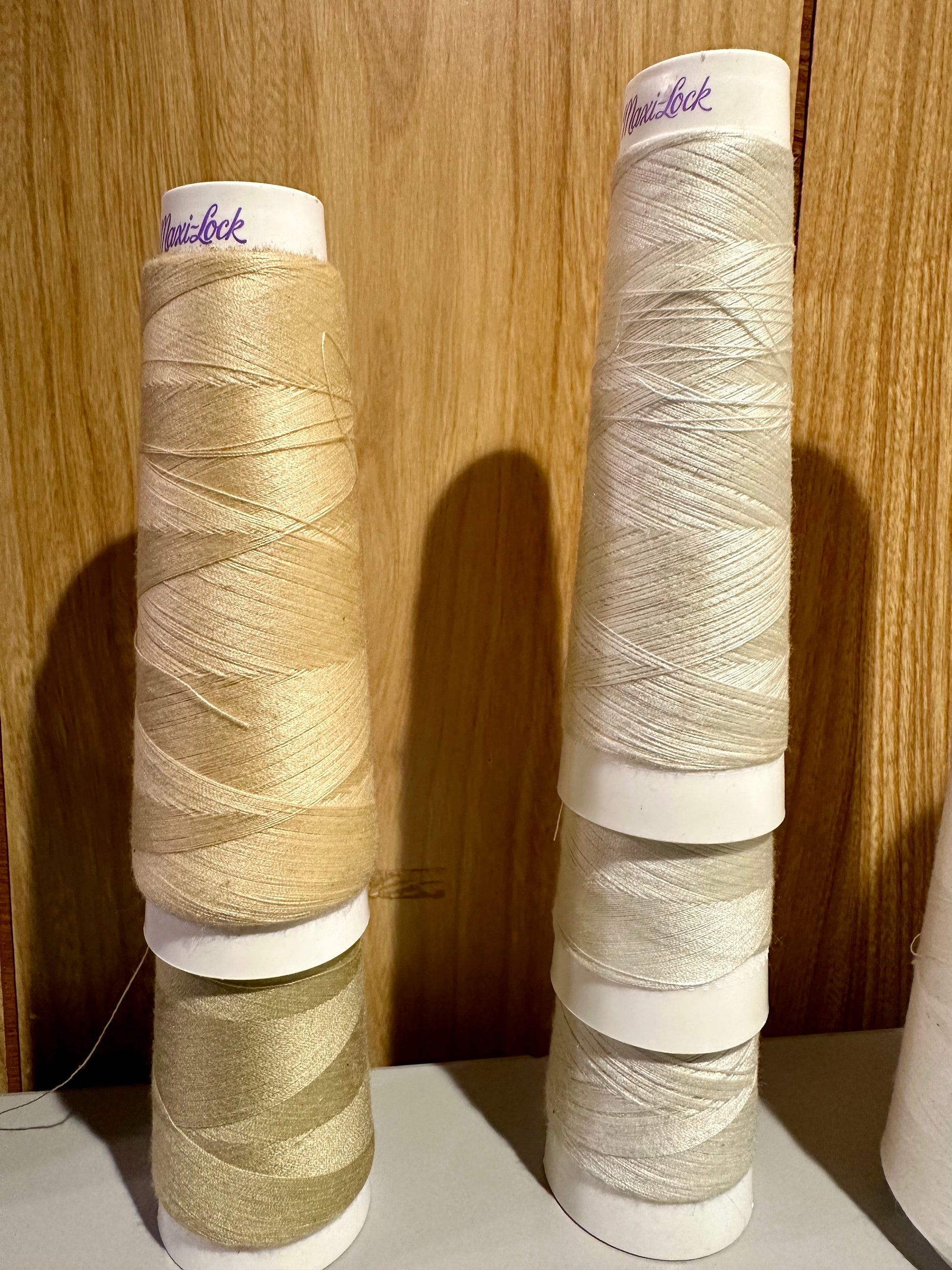 Three spools of thread with visible brand name on a wooden background