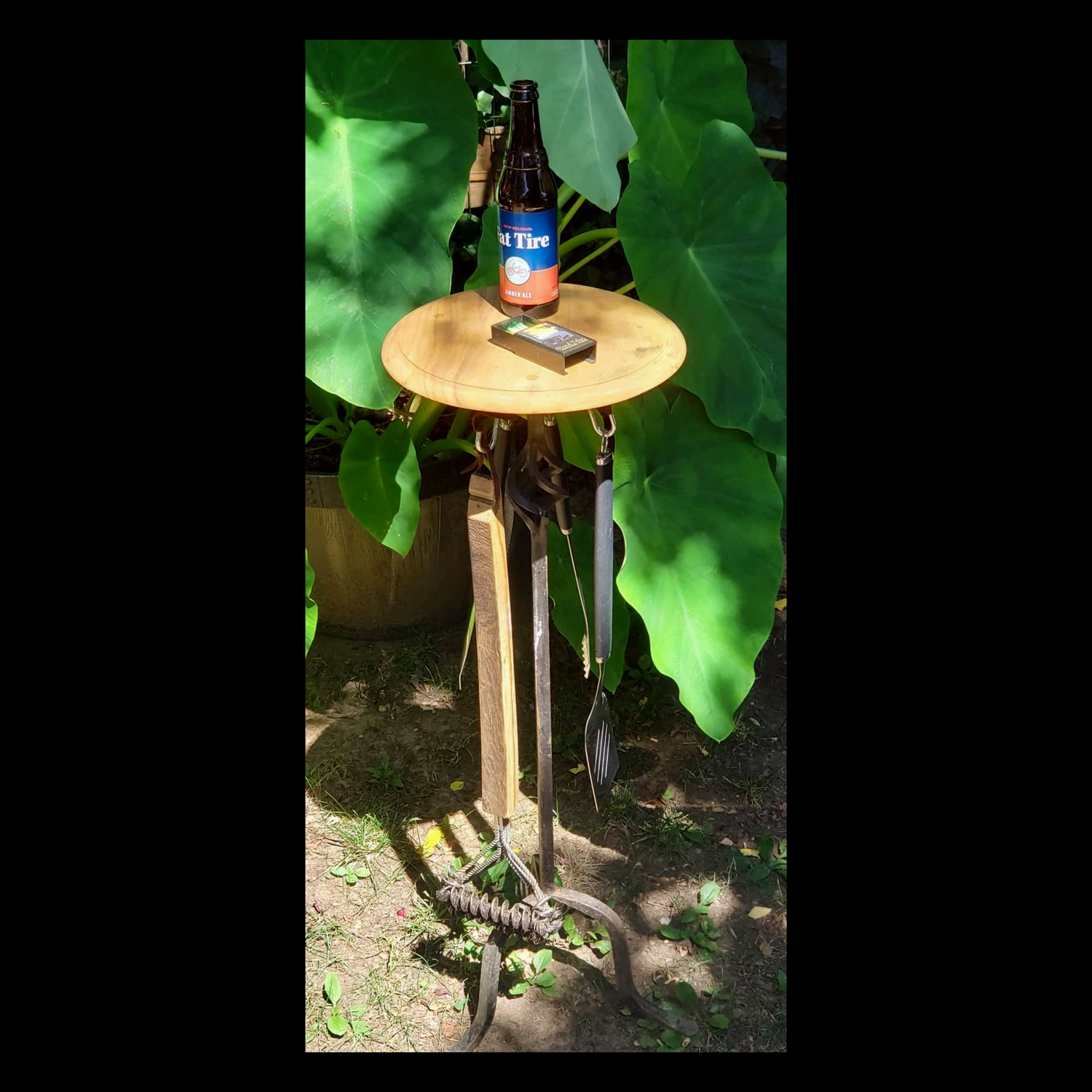Grilling table upcycled from a wrought iron candle holder, featuring three hooks for grill tools and a wooden top for plates. A Fox & Thistle Studio original.