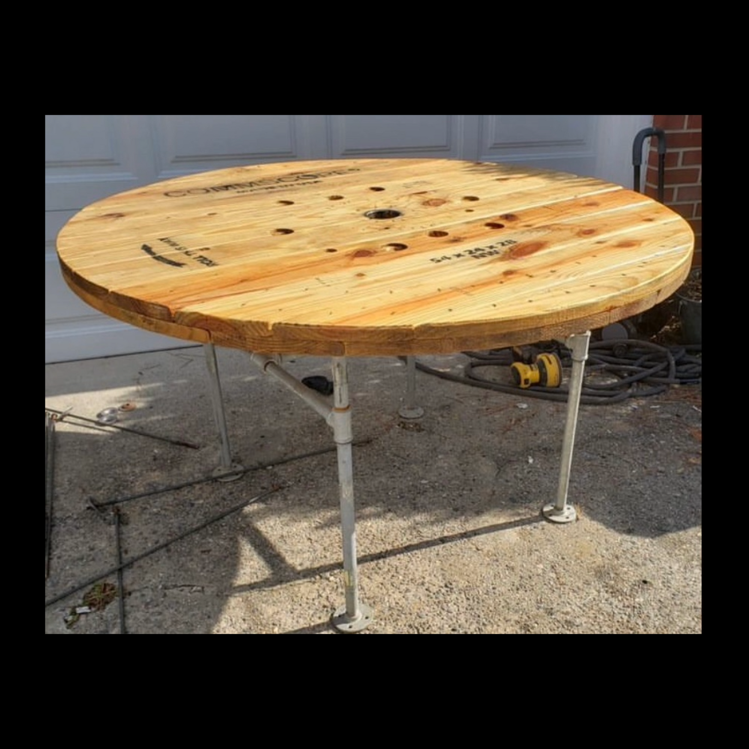 54-inch table made from a reclaimed cable spool with gas pipe legs.