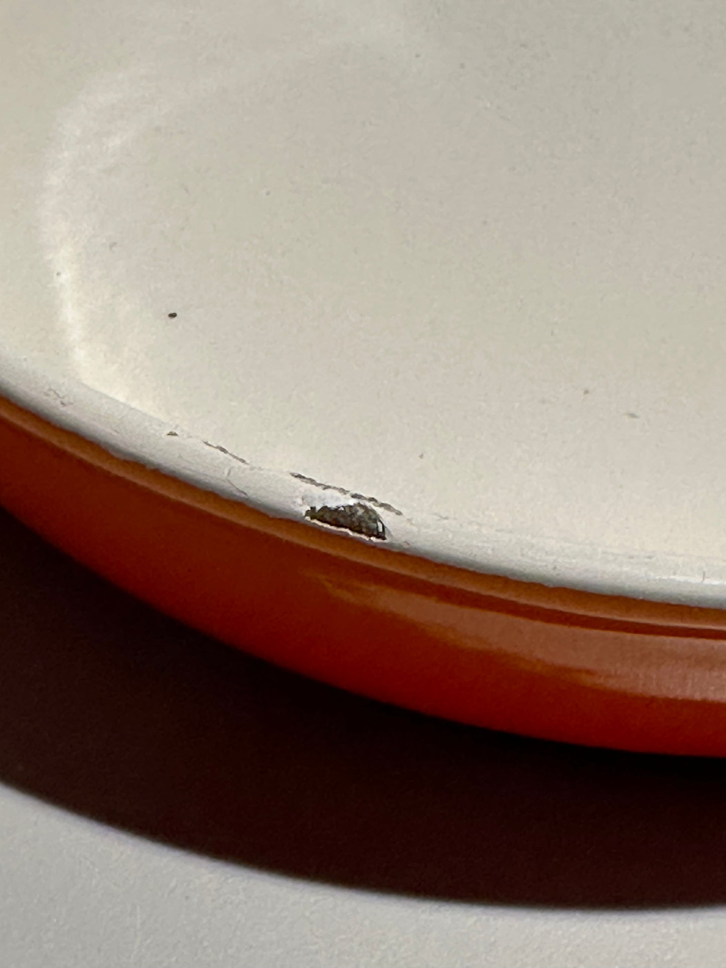 Close-up of a ceramic dish with a brown rim and white interior.