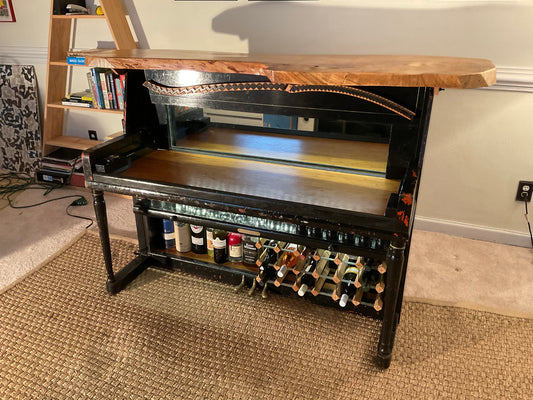 Wine rack with bottles on a wooden shelf in a room setting.