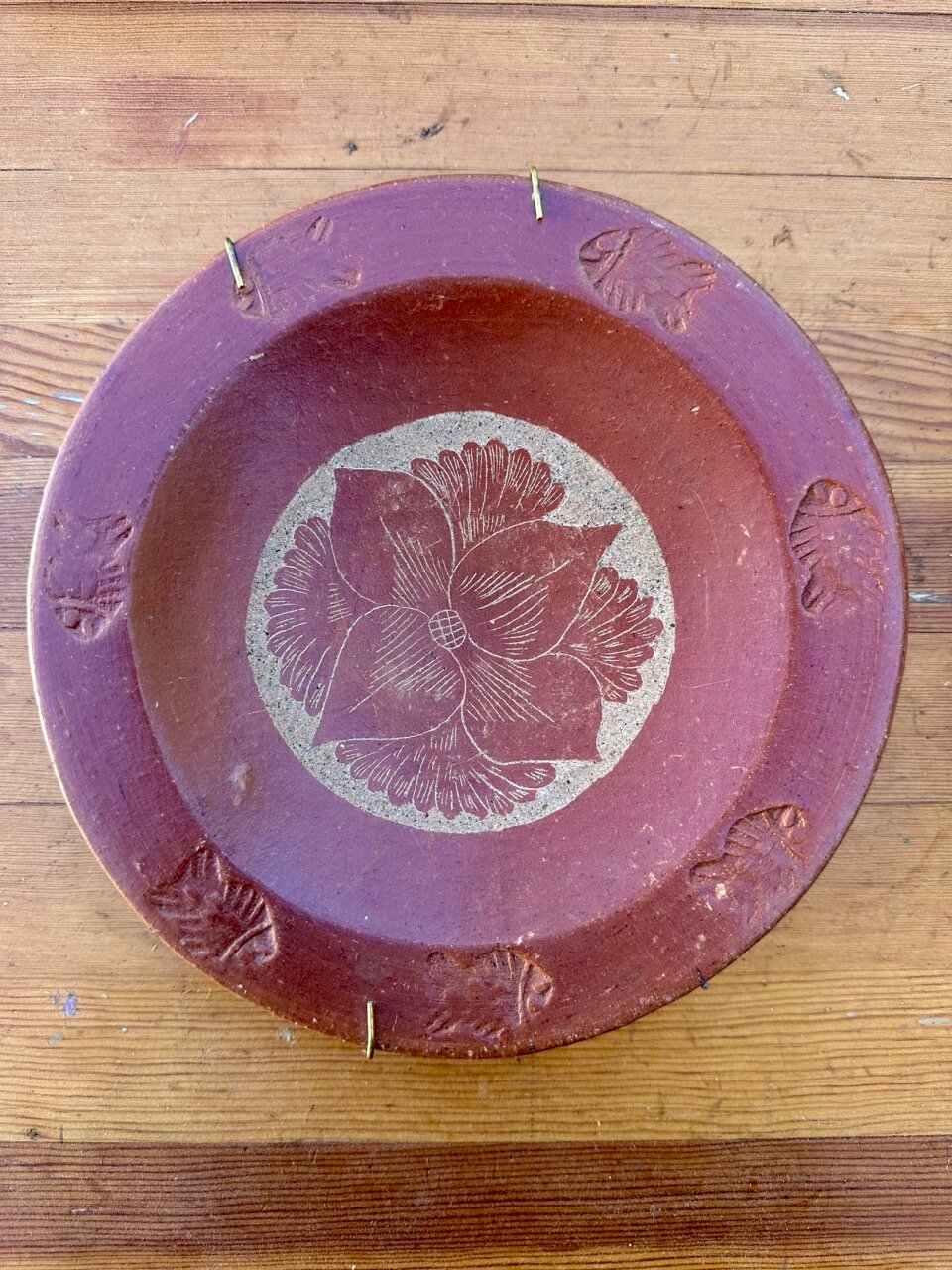 Decorative ceramic plate with floral design on a wooden surface